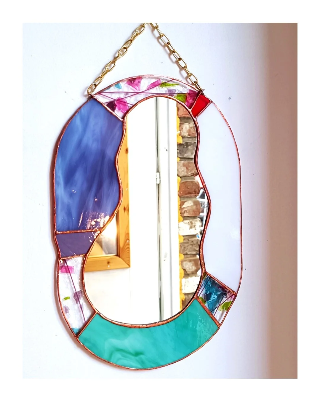 Un grand miroir en vitrail créé par Diane FRANK dans son atelier à Lille.