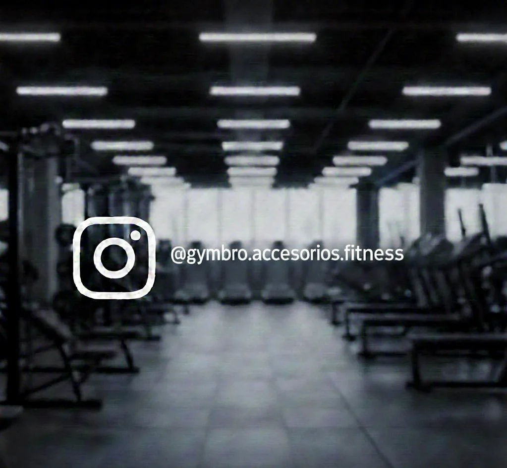 Gimnasio vacío con peso y máquinas de cardio, iluminación artificial y ventanas grandes.