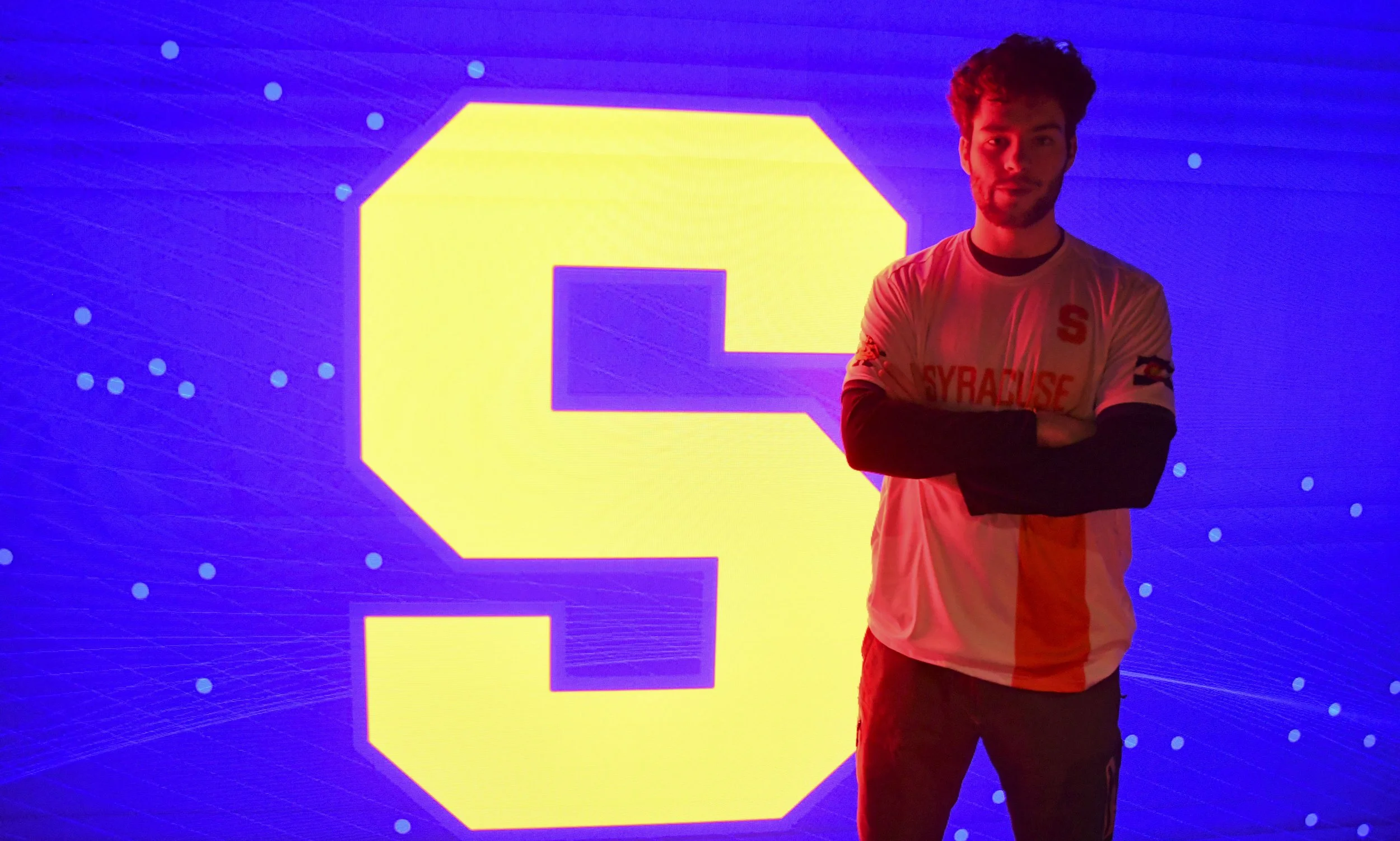 Anthony Solt poses next to the Syracuse logo.