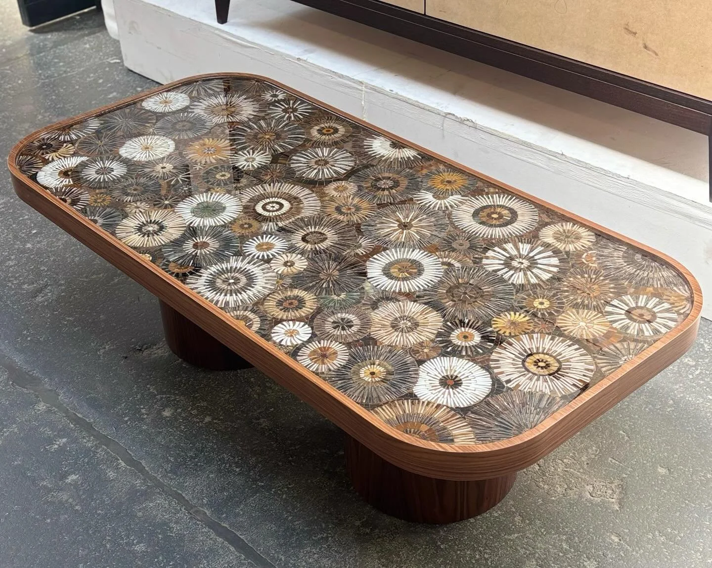 A custom Palazzo Coffee Table featuring an earth-toned Blossom mosaic sealed under resin, set atop two walnut pillar legs

Handcrafted for @lewisbirksllc