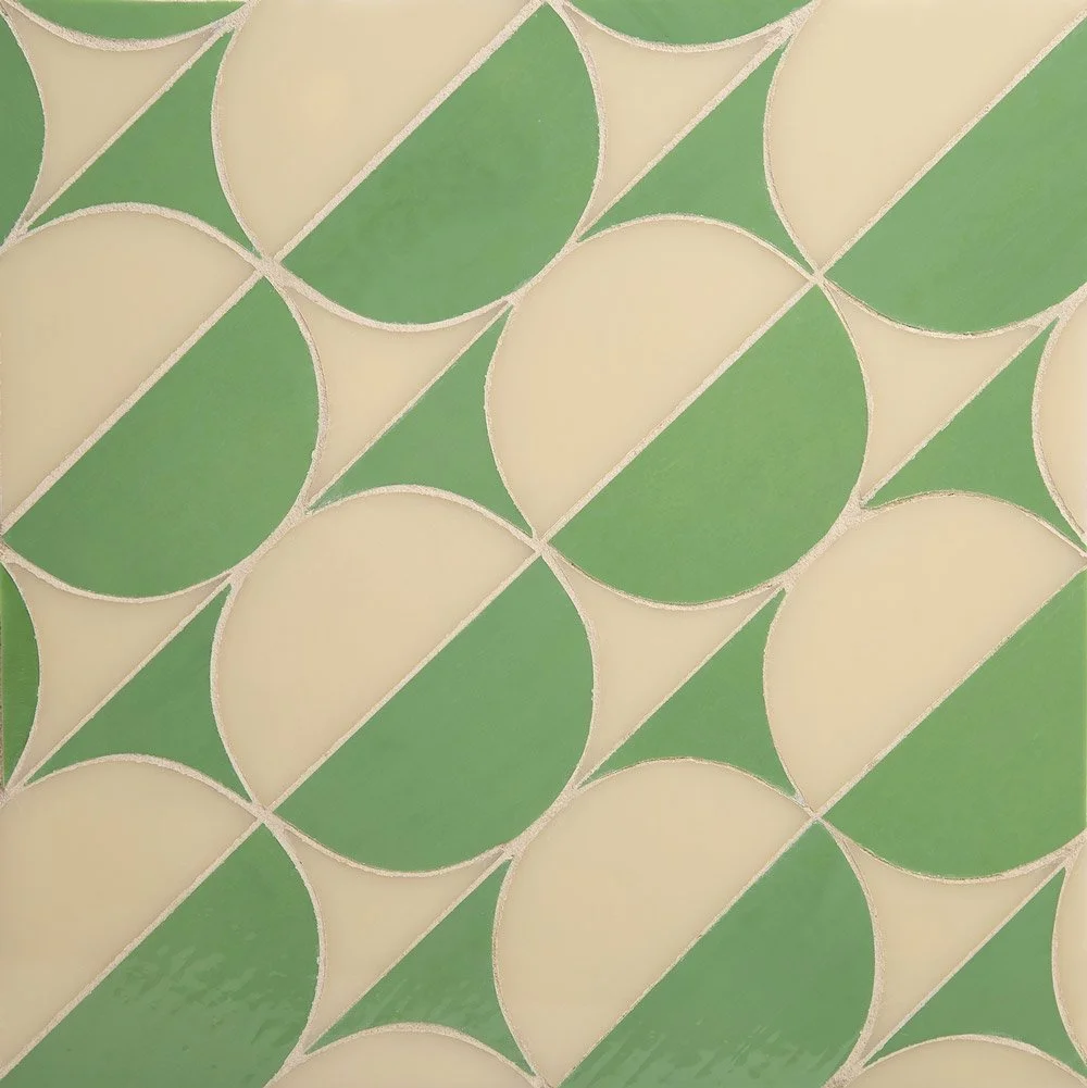 Close-up of patterned tile with alternating green and cream semicircles and triangles.