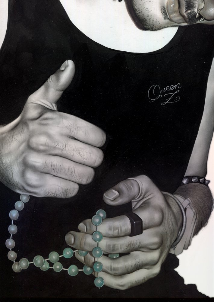 Close-up of a person's hands holding a string of beads, with the person giving a thumbs-up gesture near their chest. The person is wearing a black sleeveless shirt that has the name 'Queen Z' written on it, and bracelets and a watch on their wrist.