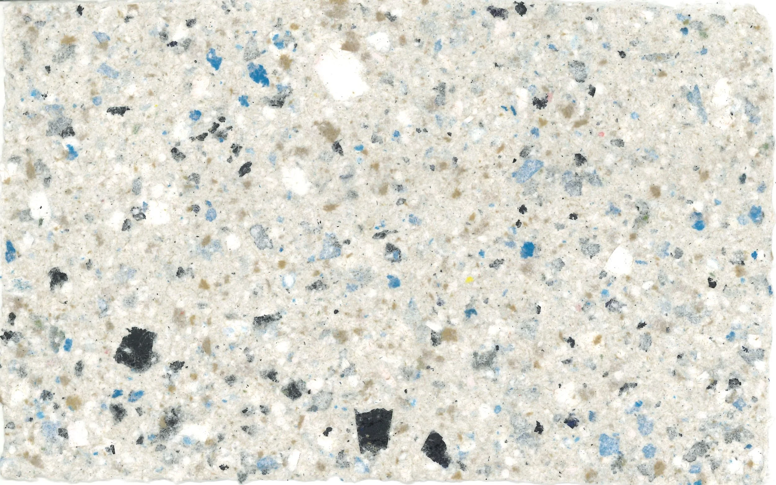 Close-up of speckled granite countertop surface with small black, blue, white, and gray particles.