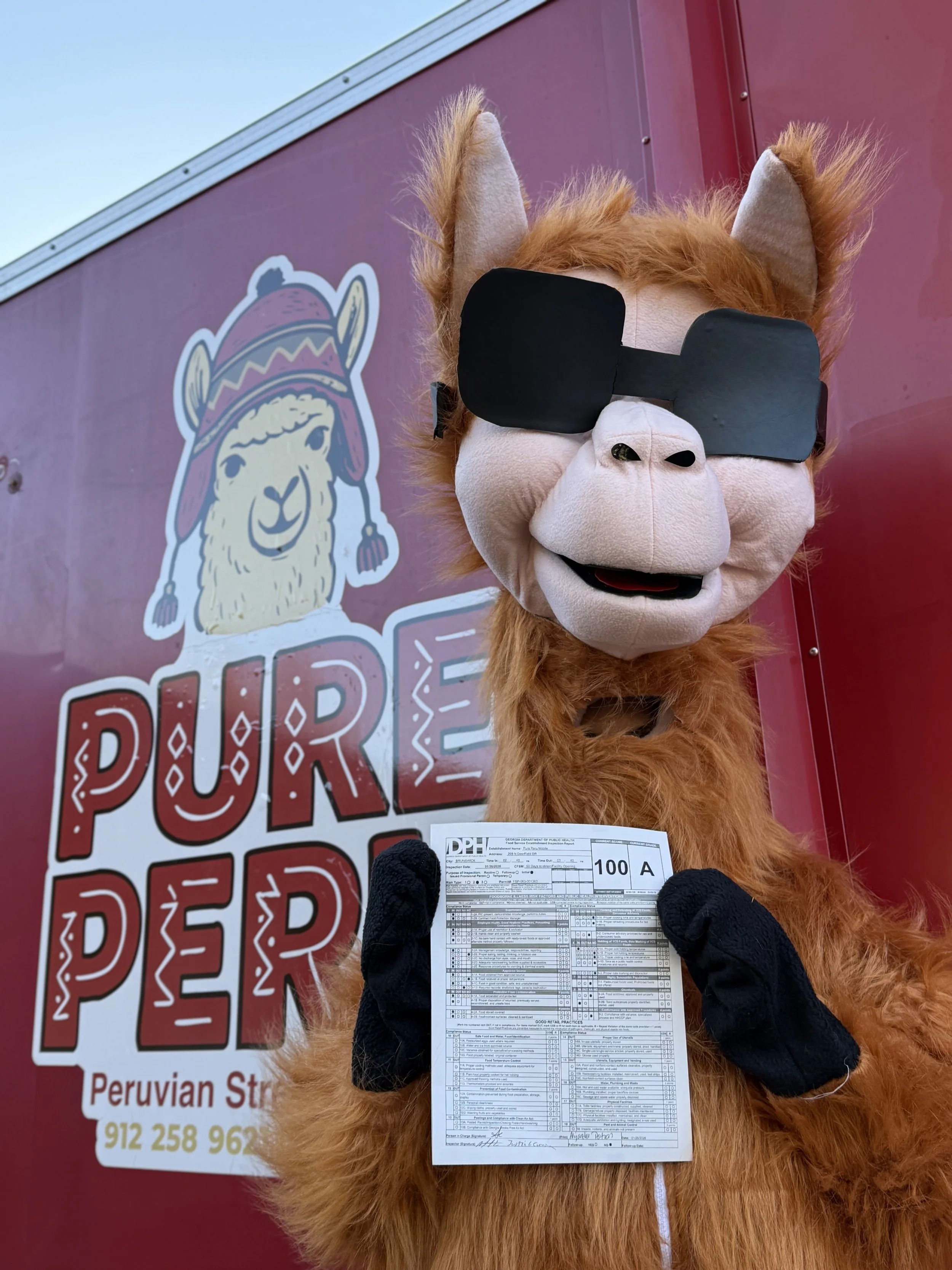 A person in a llama mascot costume with sunglasses and black gloves is holding a flight boarding pass, standing in front of a red truck with a llama logo and the words 'PURE PEPER'.