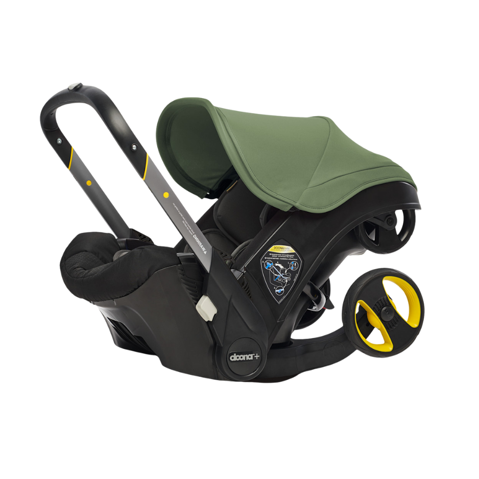 Child car seat with green canopy and black base, equipped with adjustable handle and wheels for mobility.