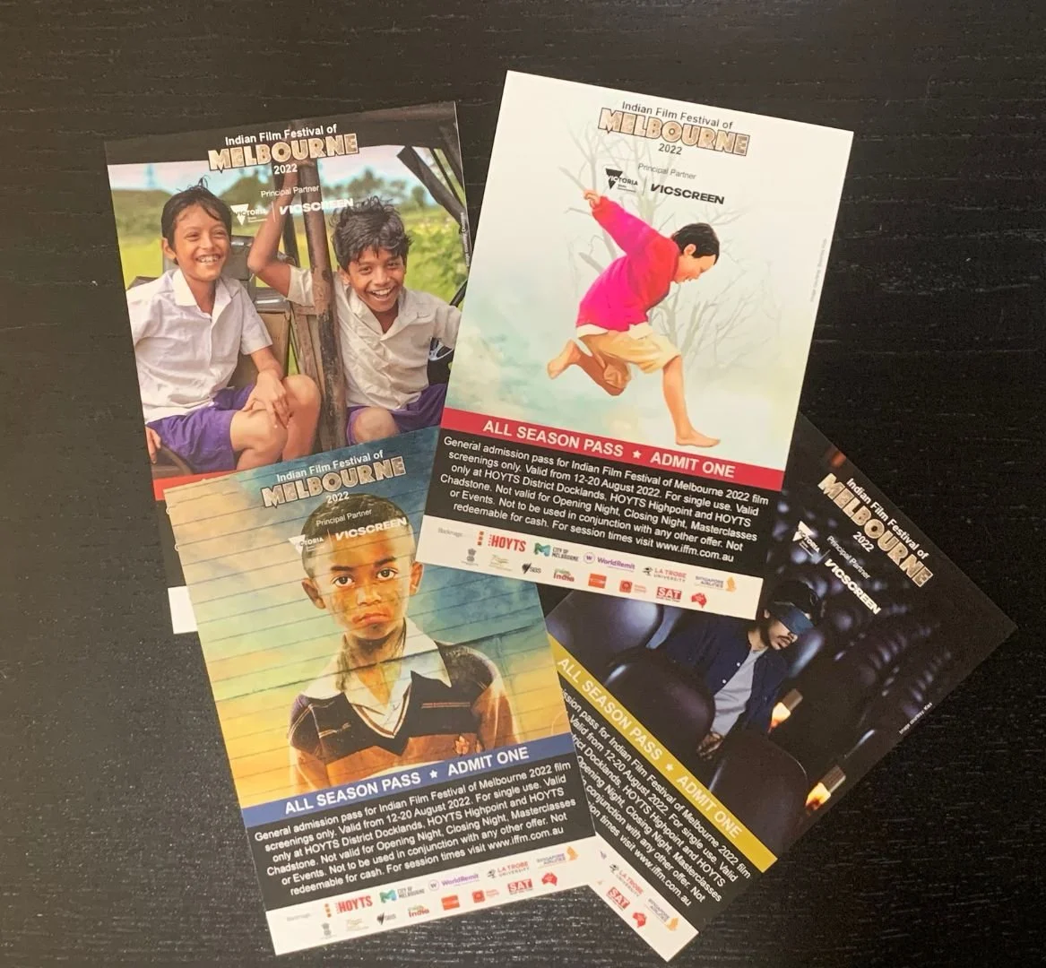Tickets for the Indian Film Festival of Melbourne 2022, featuring photos of children and teens, some smiling and one looking serious, with event details on each ticket.