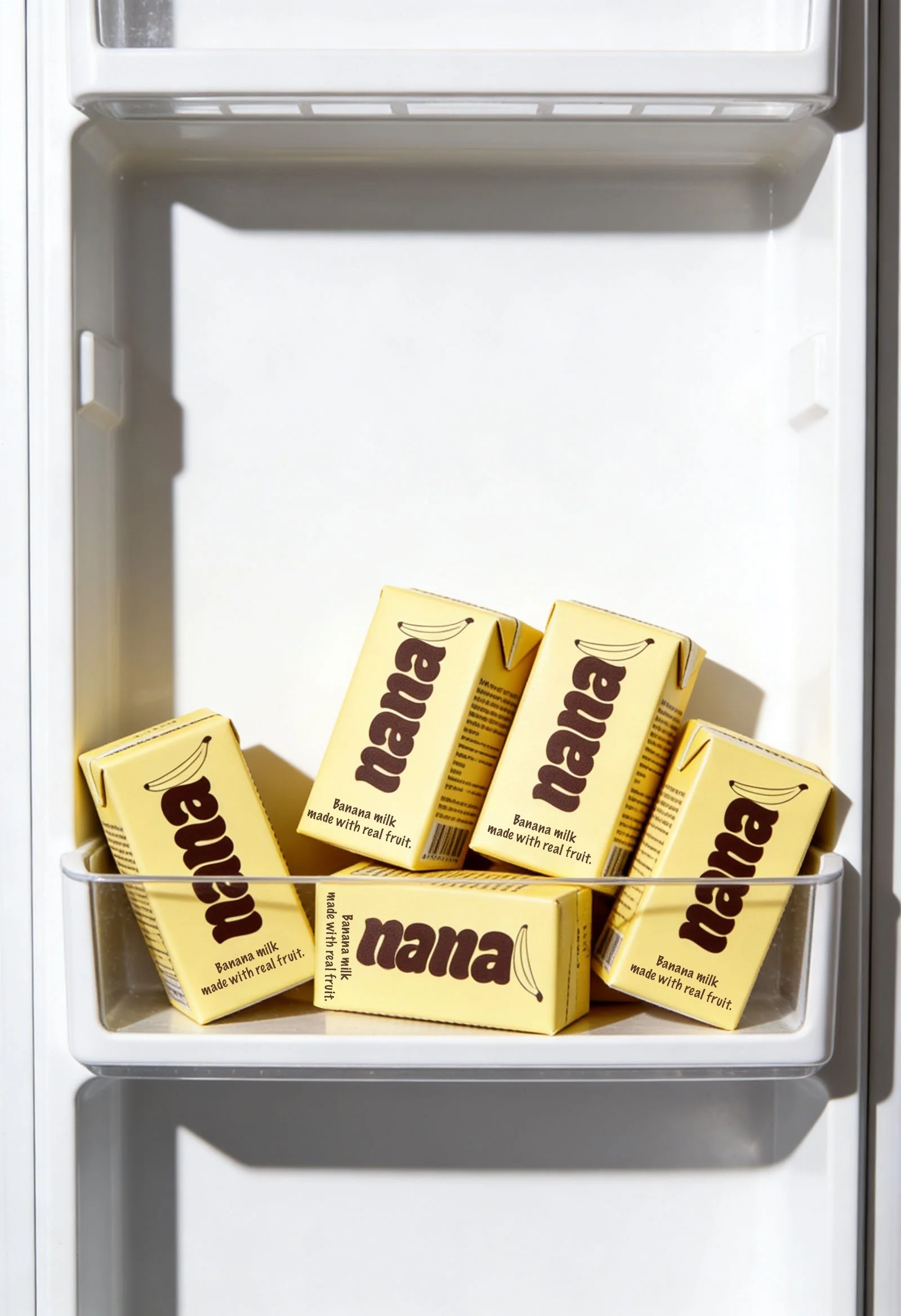 An open freezer drawer containing yellow cartons of banana milk.