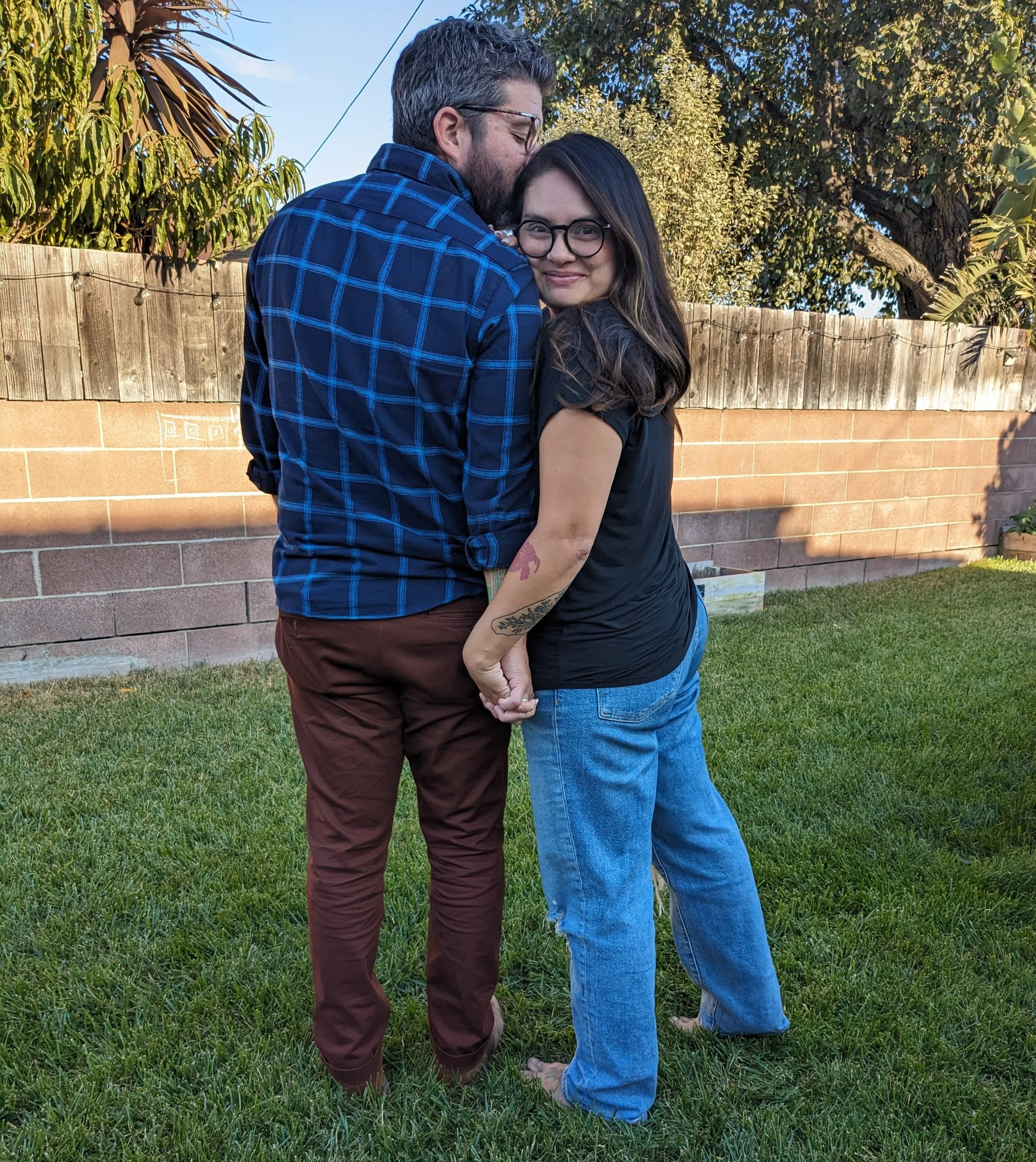 A couple holding hands in a backyard, together forever. loved