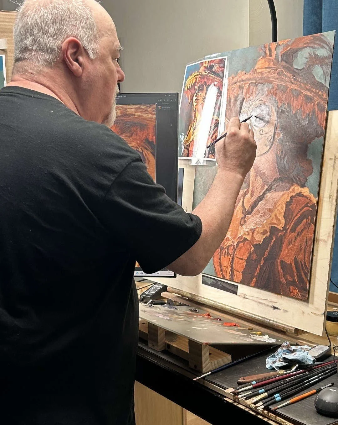 An artist painting an abstract portrait of a woman on a canvas, with a reference image pinned to the wall behind.