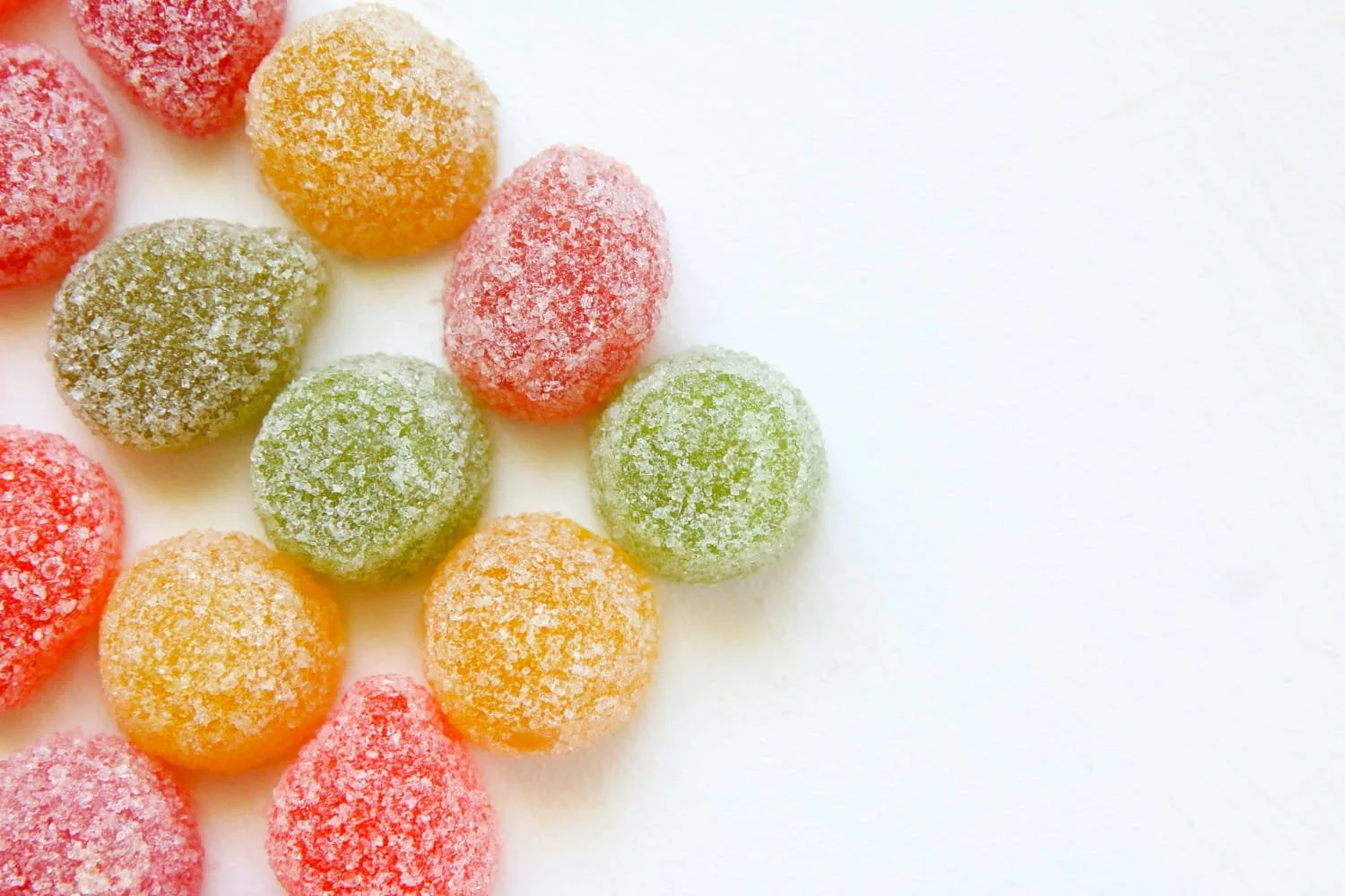Colorful sugar-coated gumdrops on a white surface