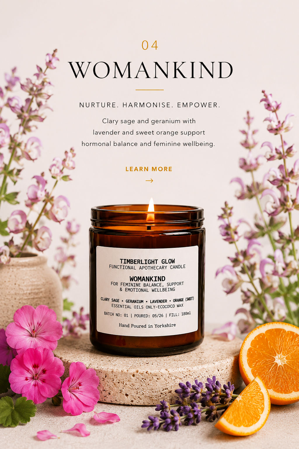 Lit TimberLight Glow WomanKind aromatherapy candle displayed with clary sage, geranium, lavender and sweet orange botanicals.