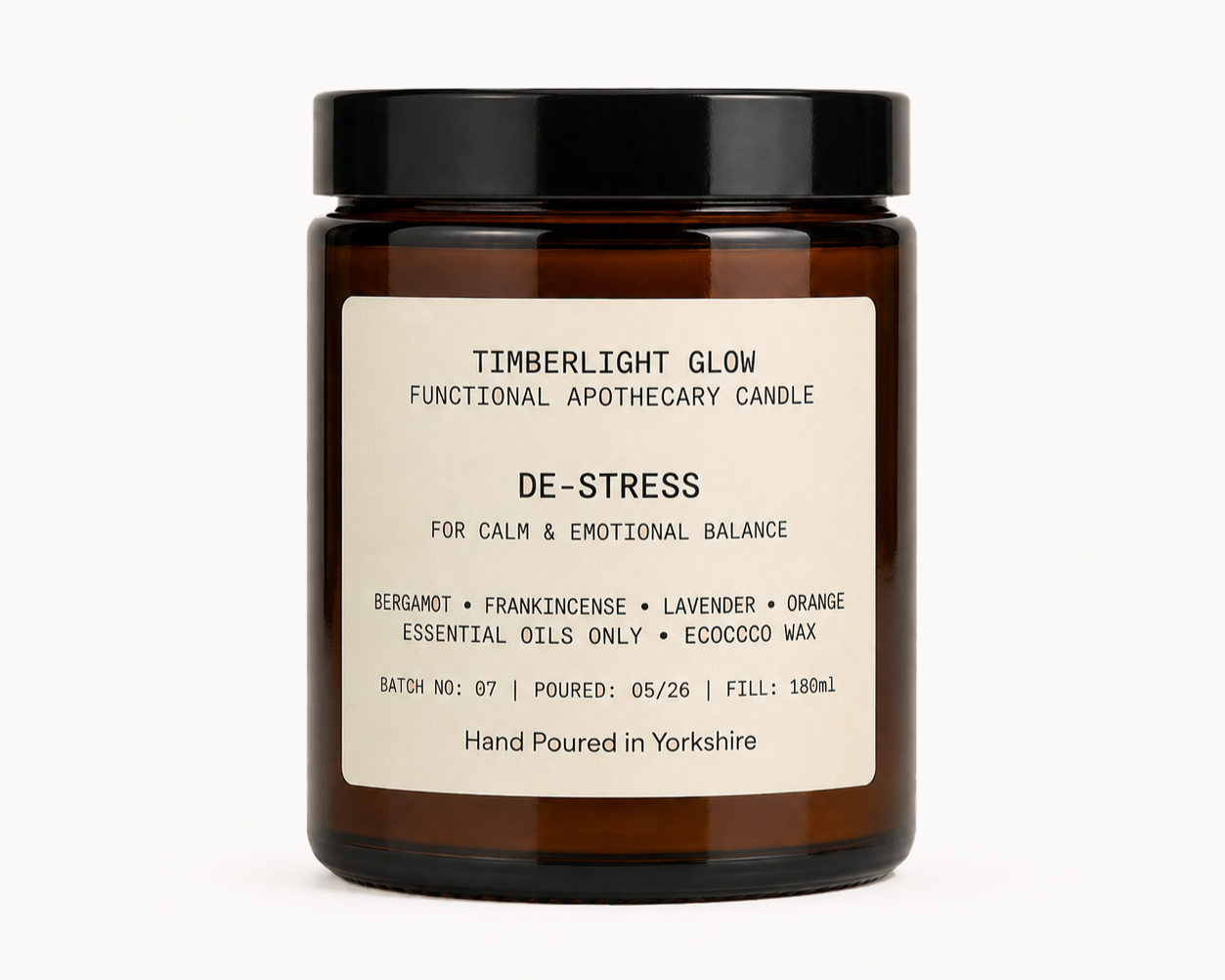 TimberLight Glow De-Stress functional apothecary candle in an amber glass jar.