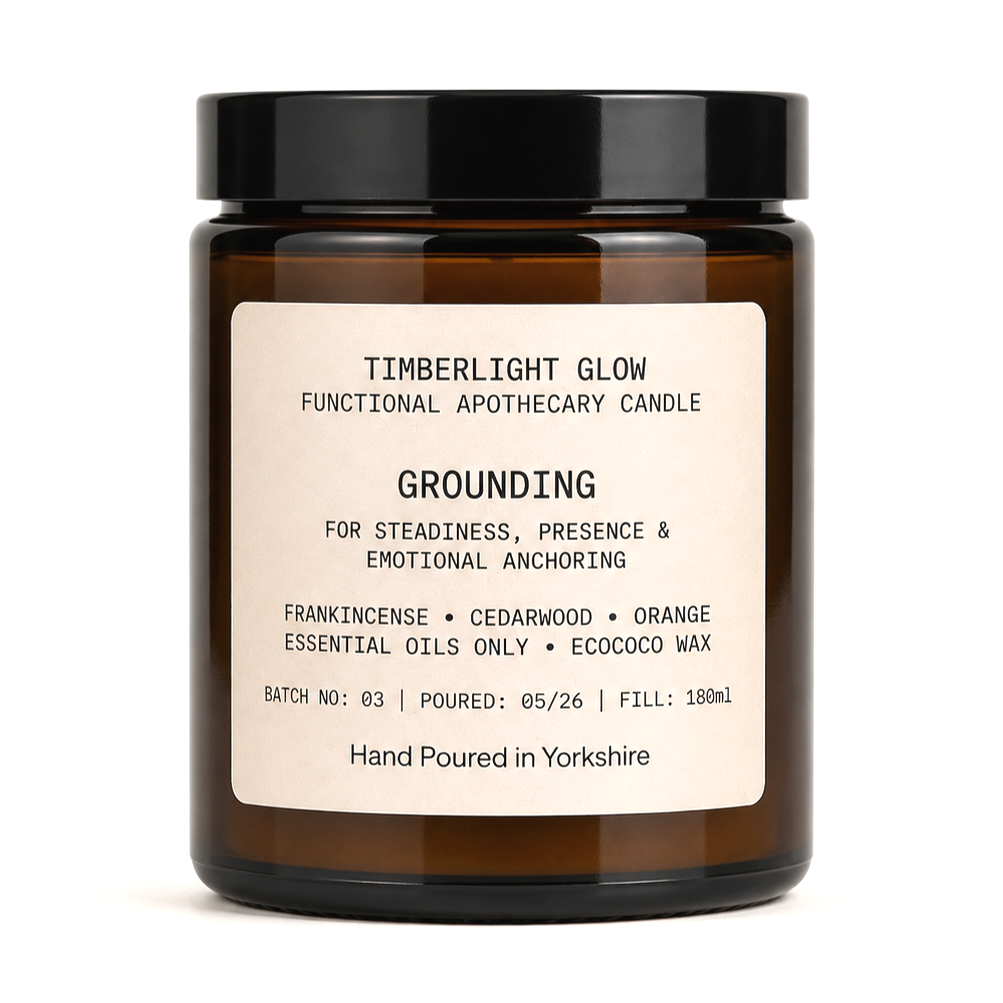 TimberLight Glow Grounding functional apothecary candle in an amber glass jar.