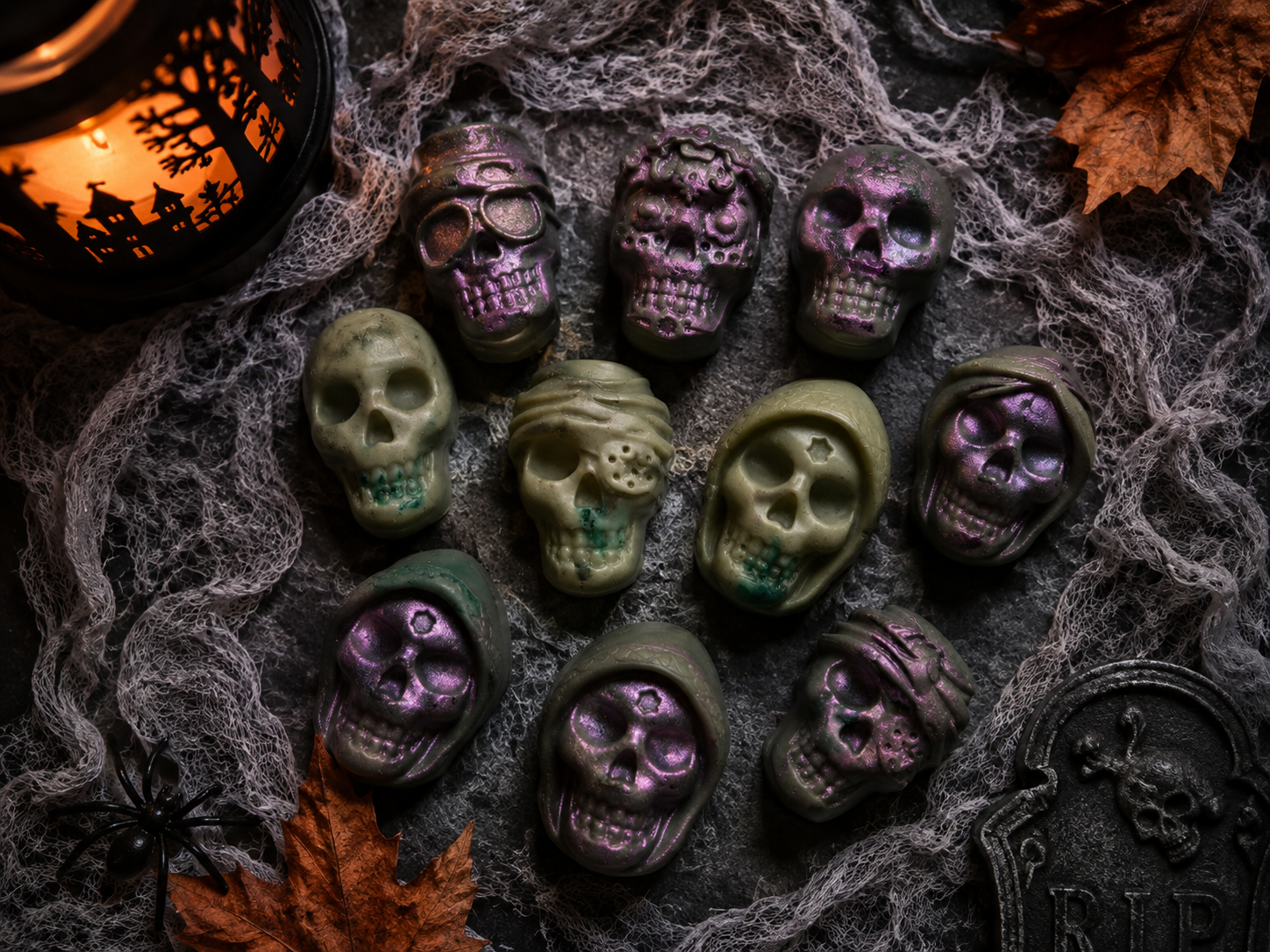 Purple and green skull-shaped Halloween wax melts with cobwebs and autumn leaves