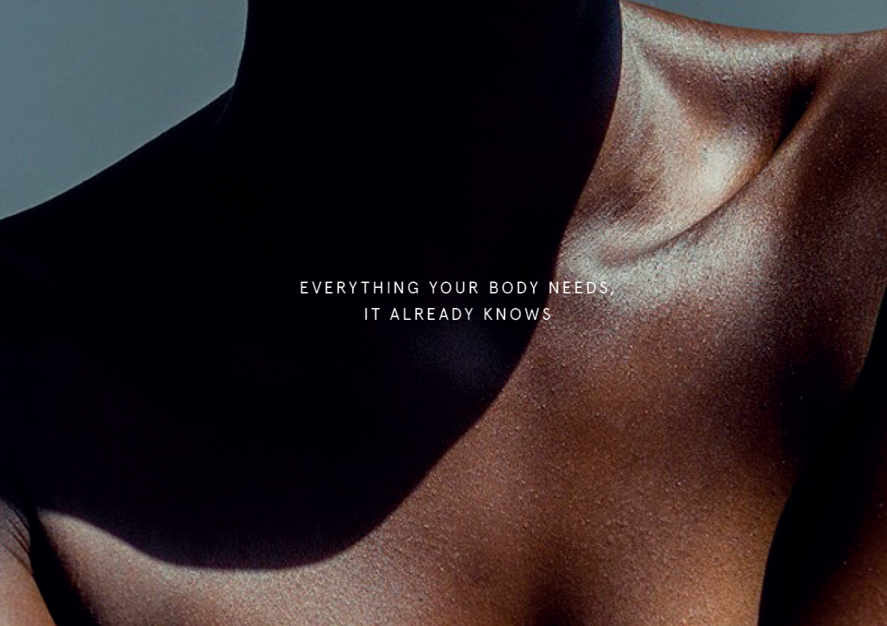 Close-up of a person's shoulder and neck with dark skin, with text that reads "Everything your body needs, it already knows."