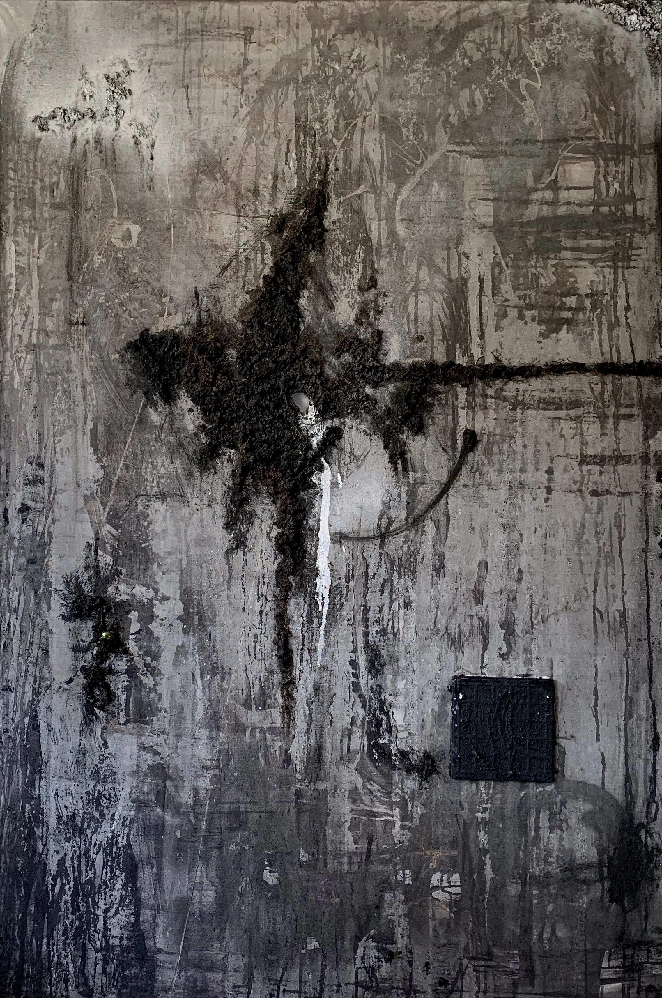 Abstract artwork with dark black and gray paint splashes and drips on a textured wall.