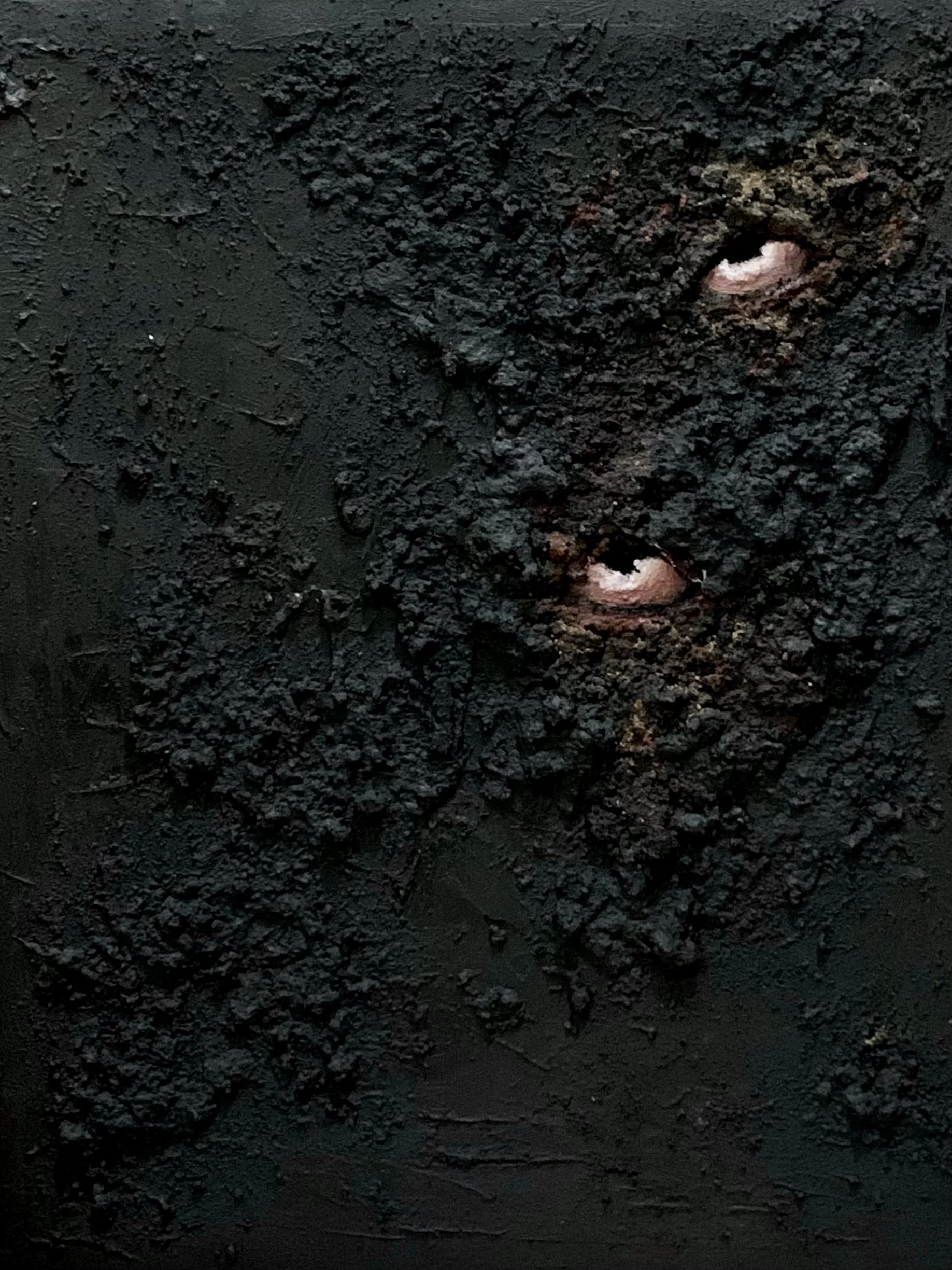 Close-up of a textured, dark surface with two small, light-colored openings or holes.