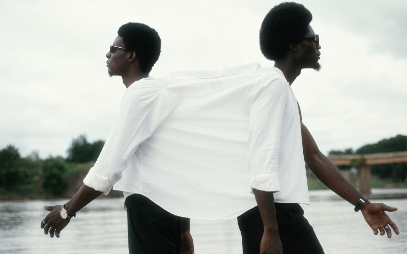 Two people standing back to back in white shirts in black and white — identity exploration and therapy for neurodivergent adults at The Relational Space