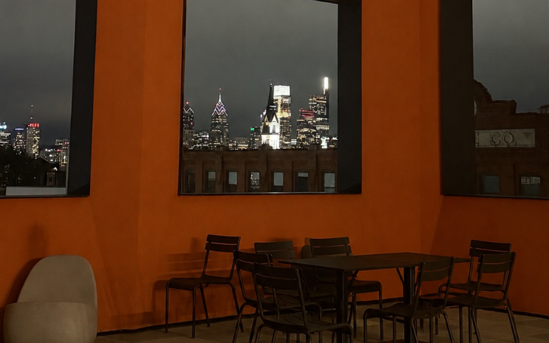 Warmly lit Philadelphia cafe at night with city skyline visible through the window — The Relational Space, therapy Philadelphia PA and NJ
