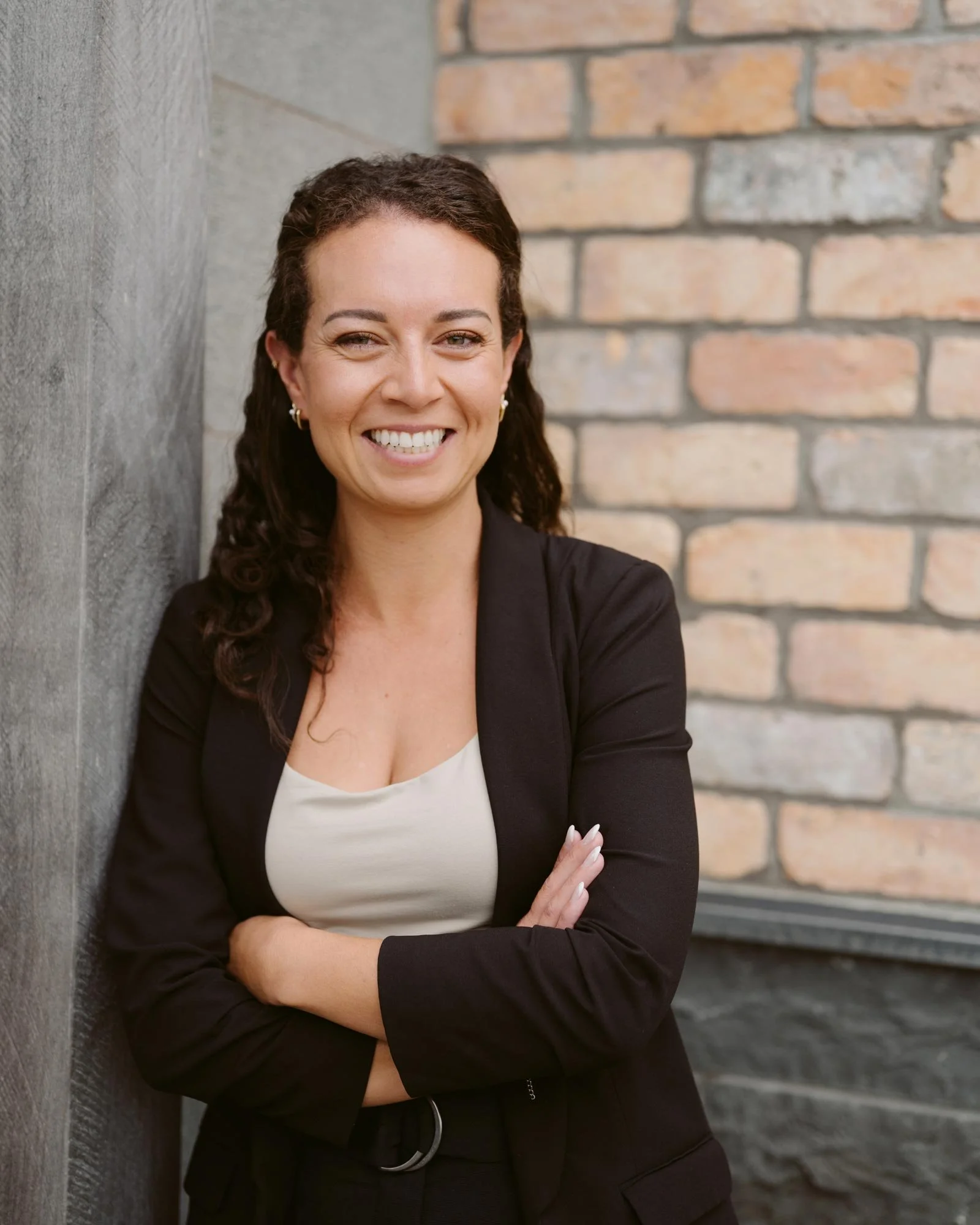 Profile photo of Shannen Lyons, smiling and leaning against wall of The Advisory's office