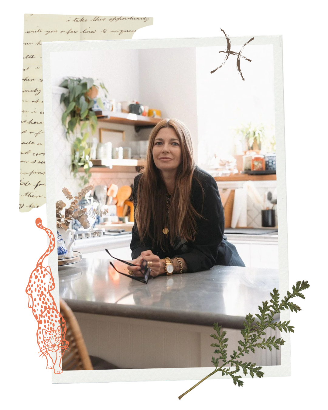A woman with long brown hair, wearing a black jacket and gold jewelry, sitting at a kitchen counter with her hands resting on the surface, holding sunglasses. The background features kitchen shelves with various items and a window with natural light.