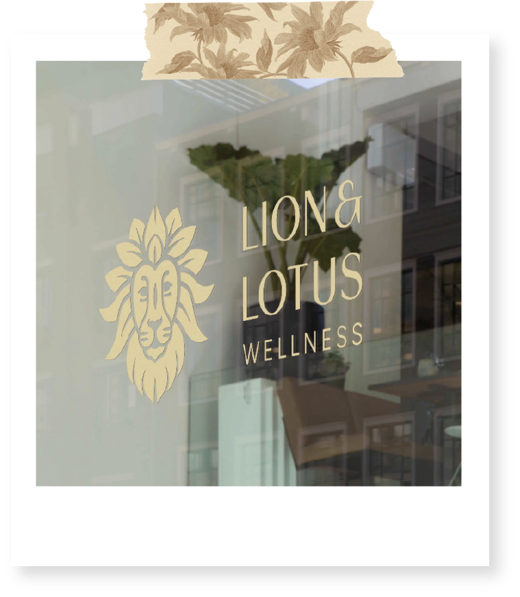 Glass window with the logo and name of Lion & Lotus Wellness, featuring a lion's head in a minimalist line art style.