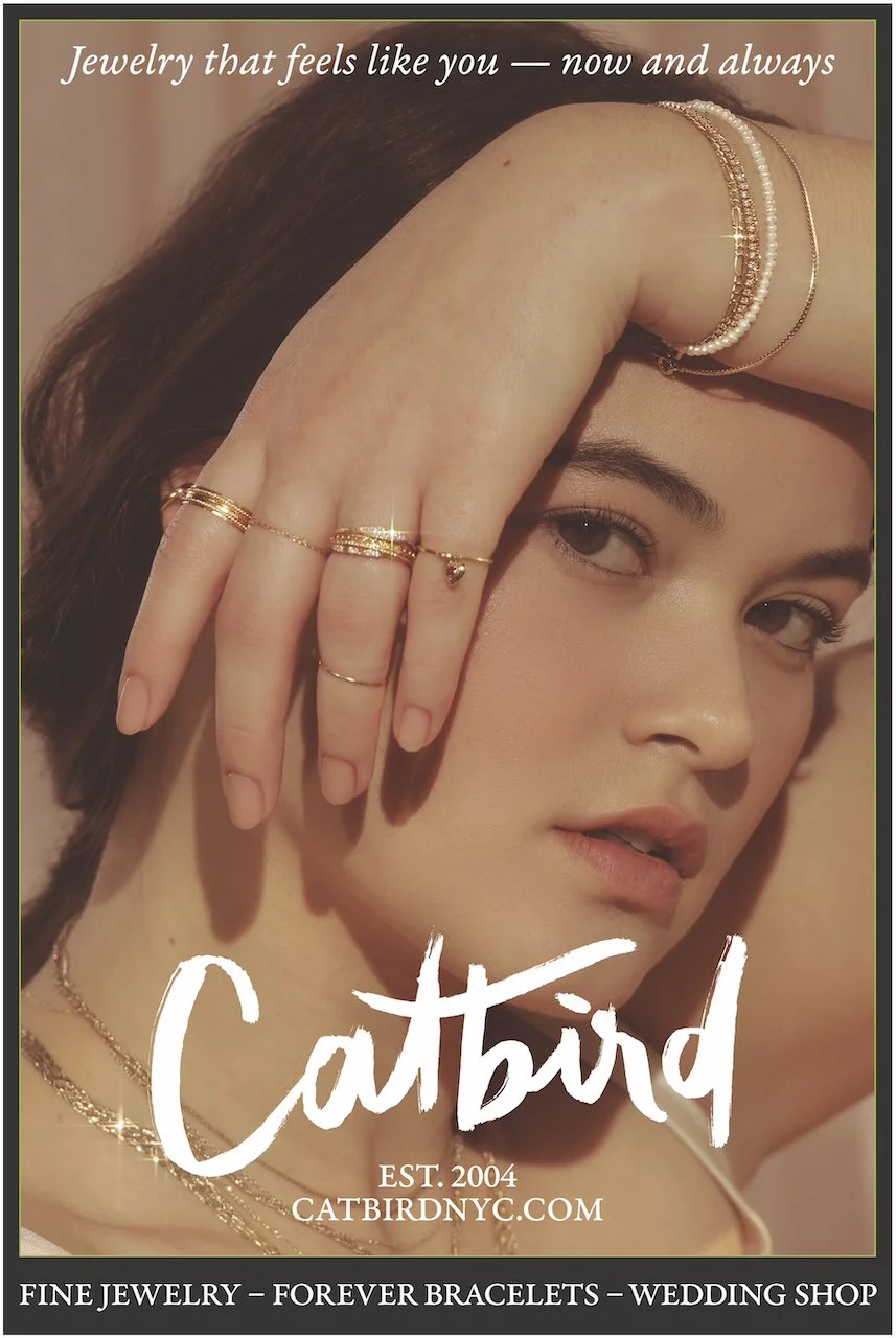 A young woman with dark hair and fair skin wearing multiple gold and pearl bracelets, rings, and necklaces. She is holding her head with her hand, showcasing her jewelry. The image includes text about jewelry and a website for a jewelry store, Catbir