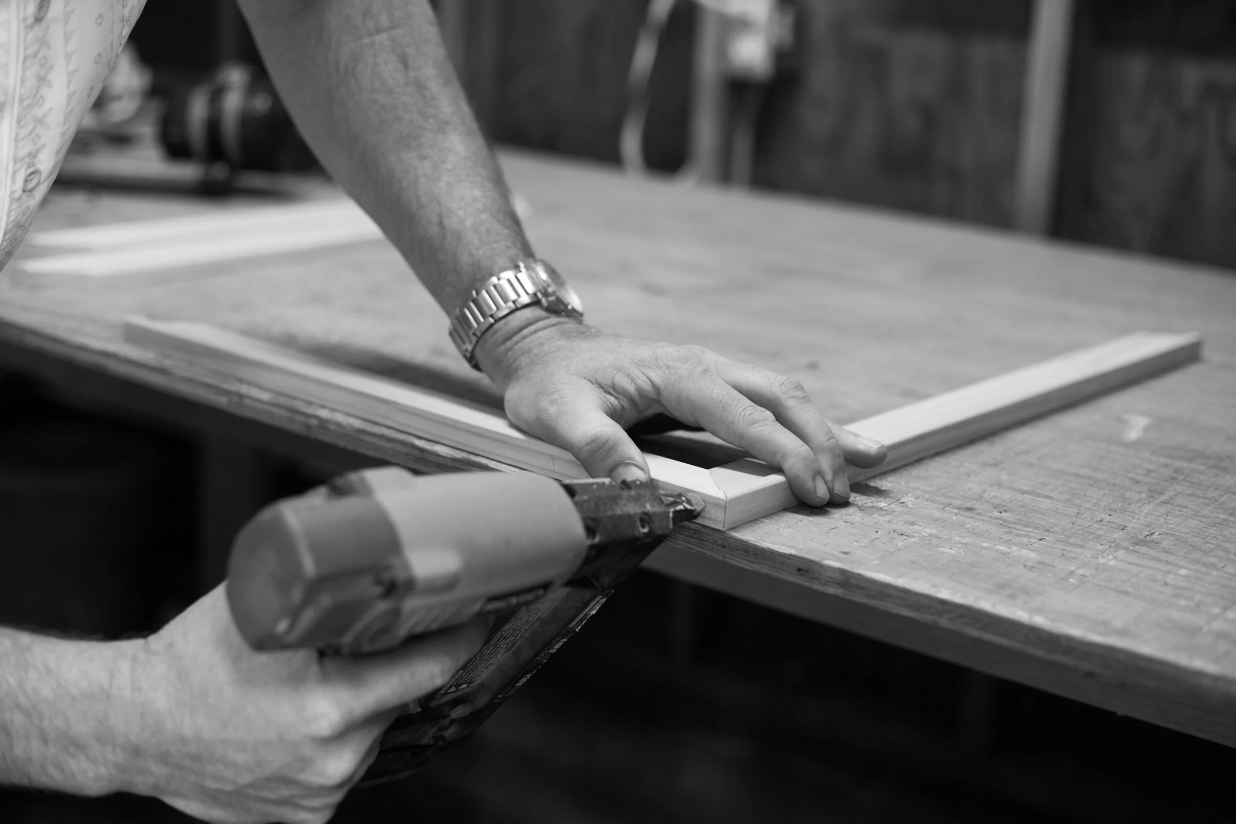 Person gluing a frame at a woodworking shop