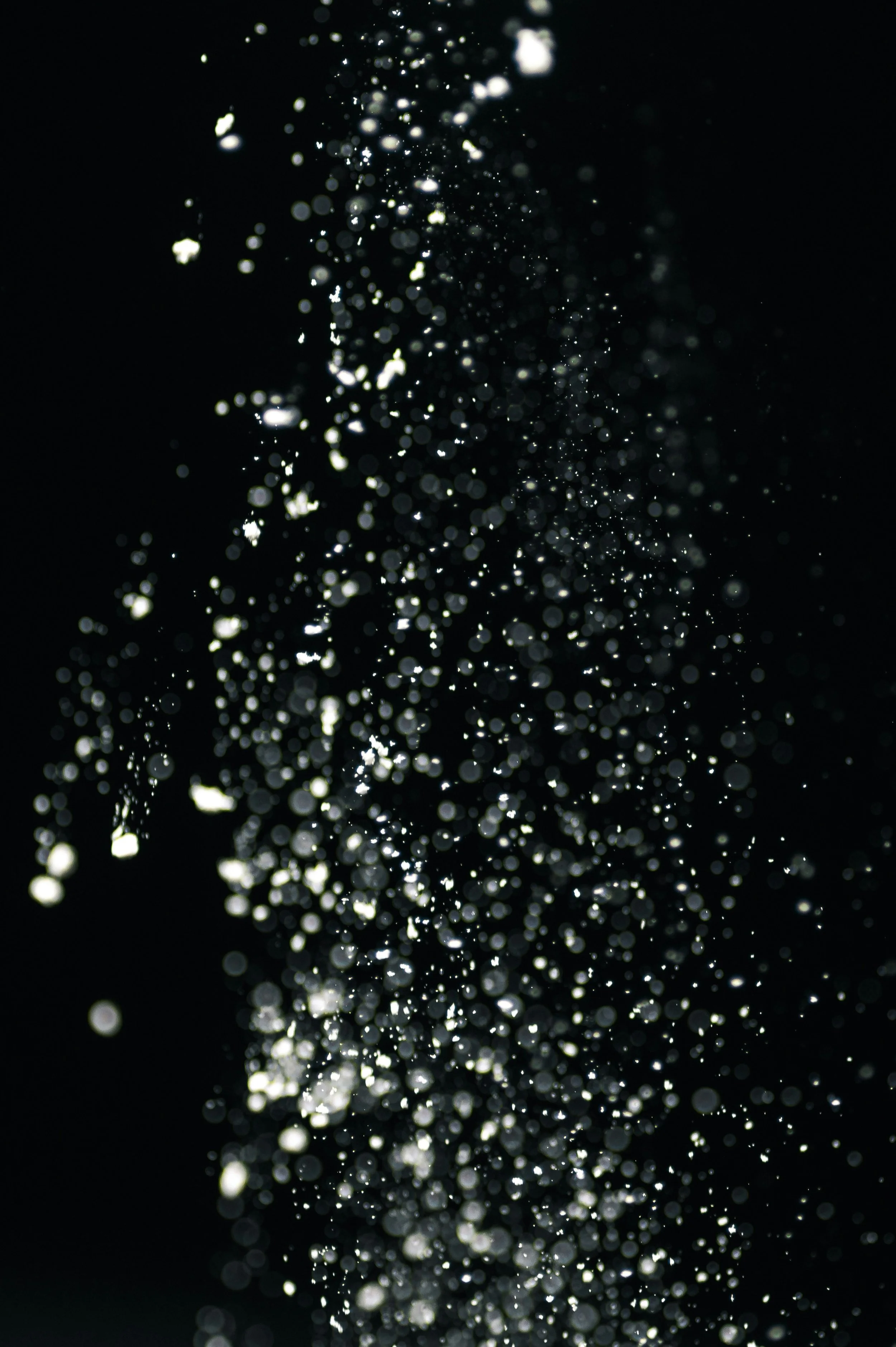 Close-up of water droplets illuminated against a black background.