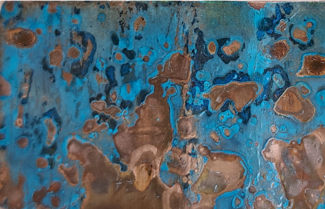 Close-up view of a rusted metal surface with blue and brown patina.