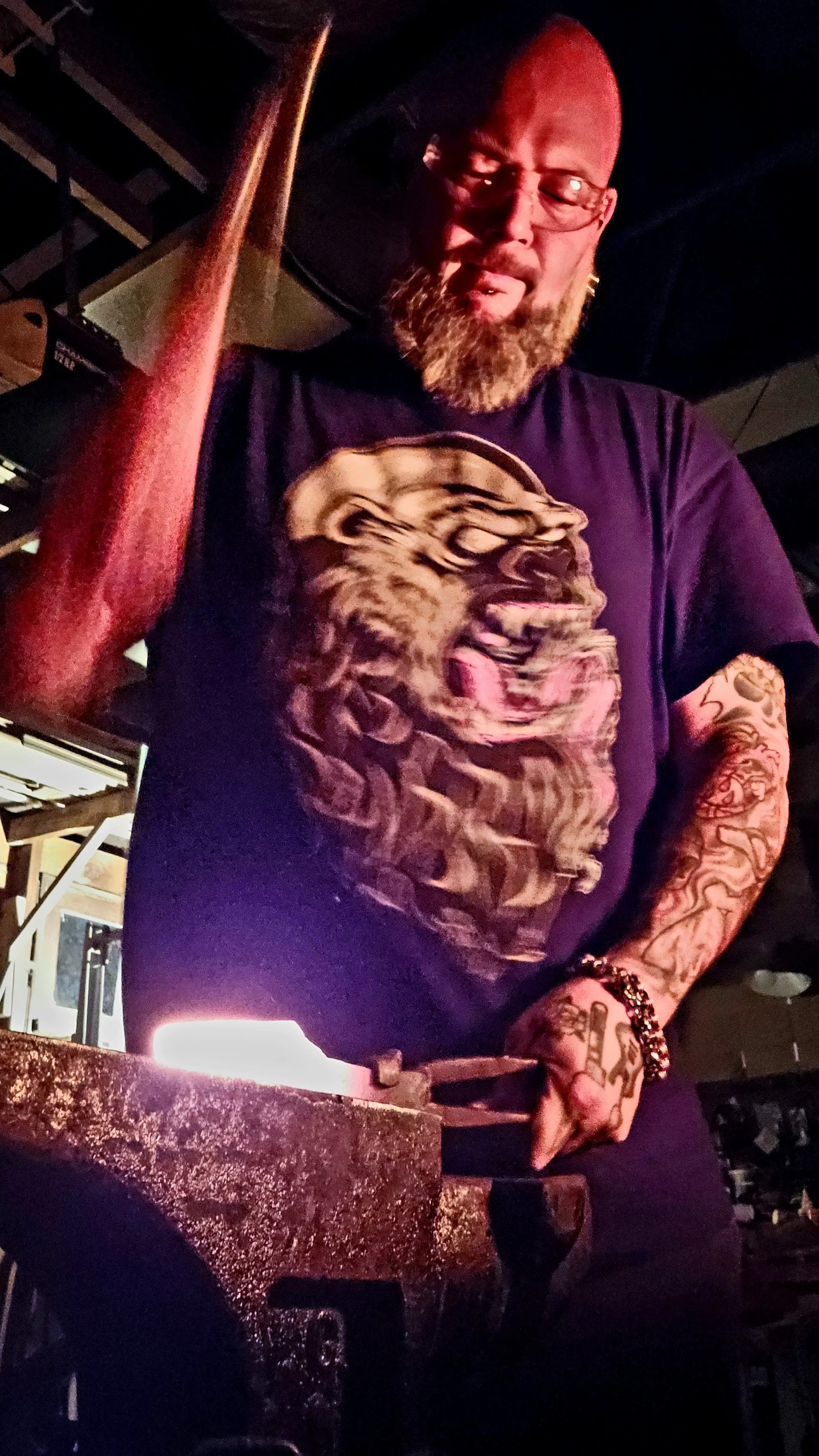 Blacksmith working at an anvil in a dimly lit workshop.