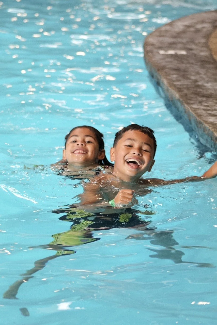 Two kids laughing in the heated indoor pool at Silver Stone Castle, Swansea, MA