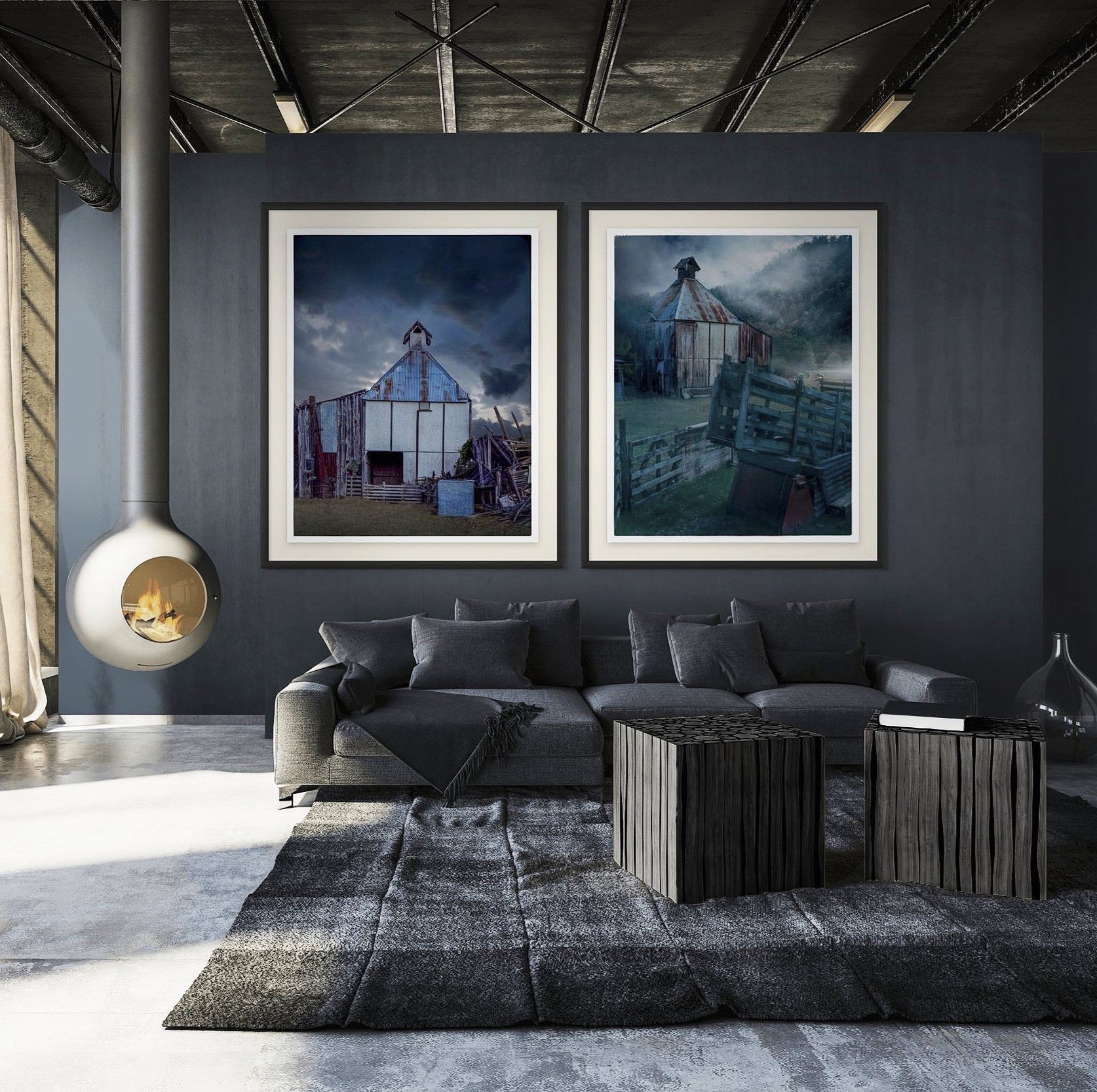 Modern living room featuring a dark gray sofa with pillows, a black rug, two black wooden side tables, a fireplace, and two large framed photos of old wooden hop kilns on the dark gray wall.