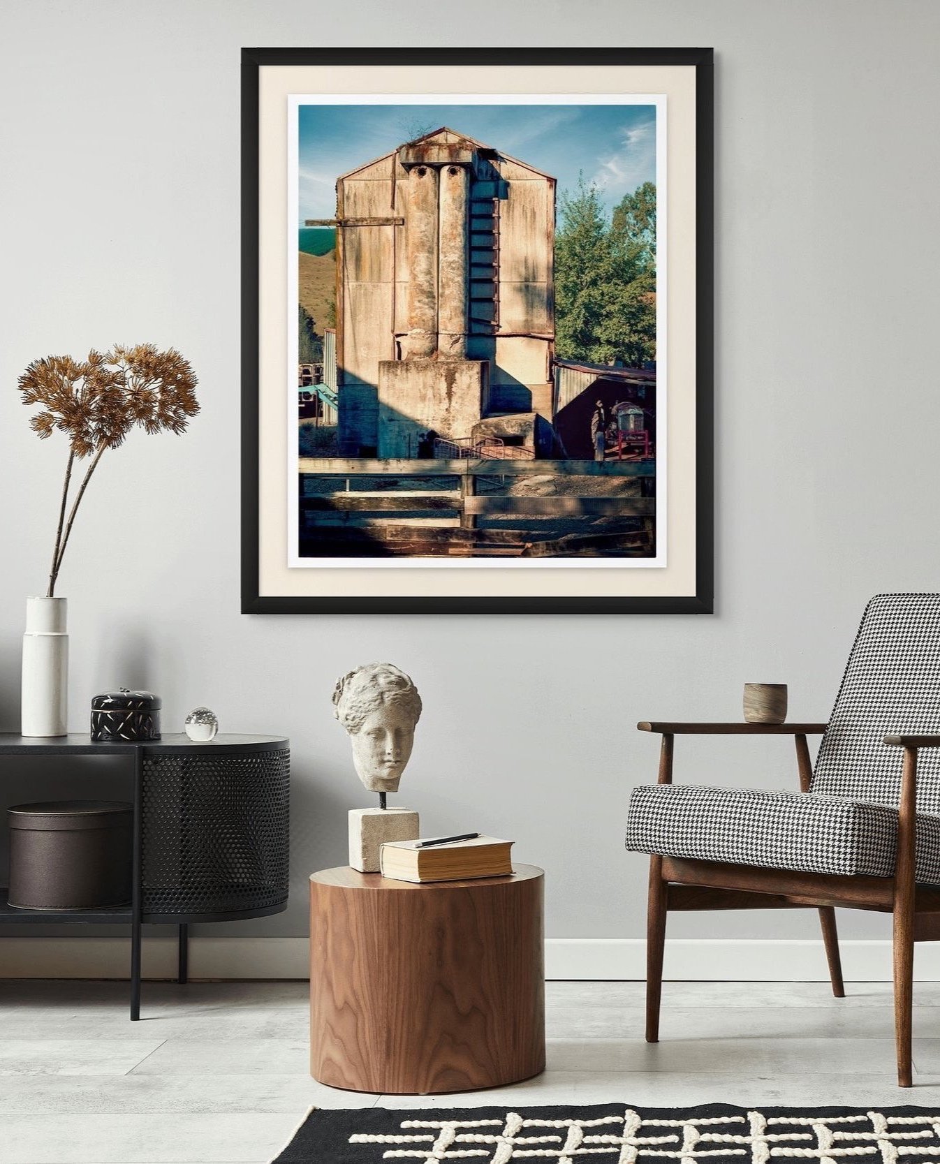 Decorative framed photo of an old hop kilns with trees and blue sky in the background, mounted on a light grey wall in a modern living room.