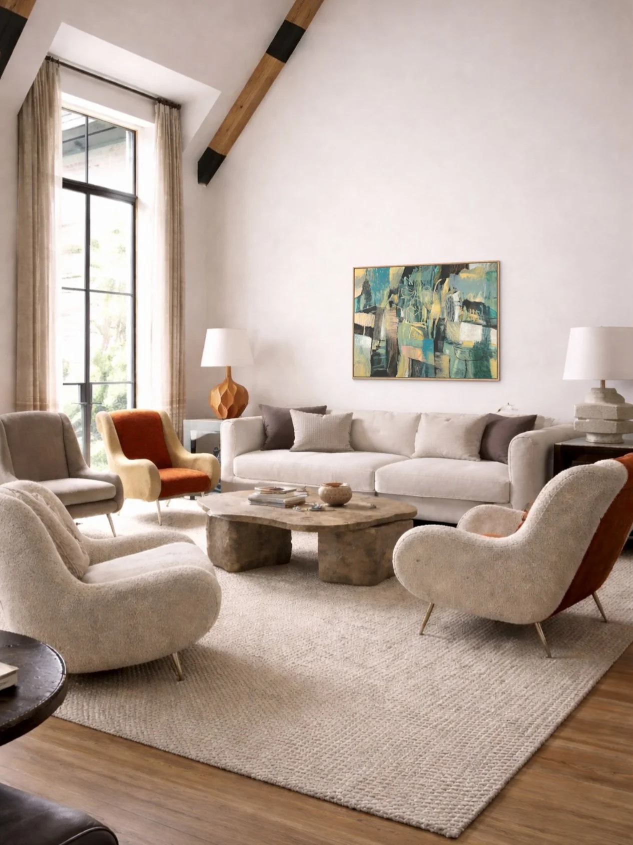 A cozy living room with large window, beige sofa, colorful armchairs, rustic coffee table, abstract artwork, and soft lighting.