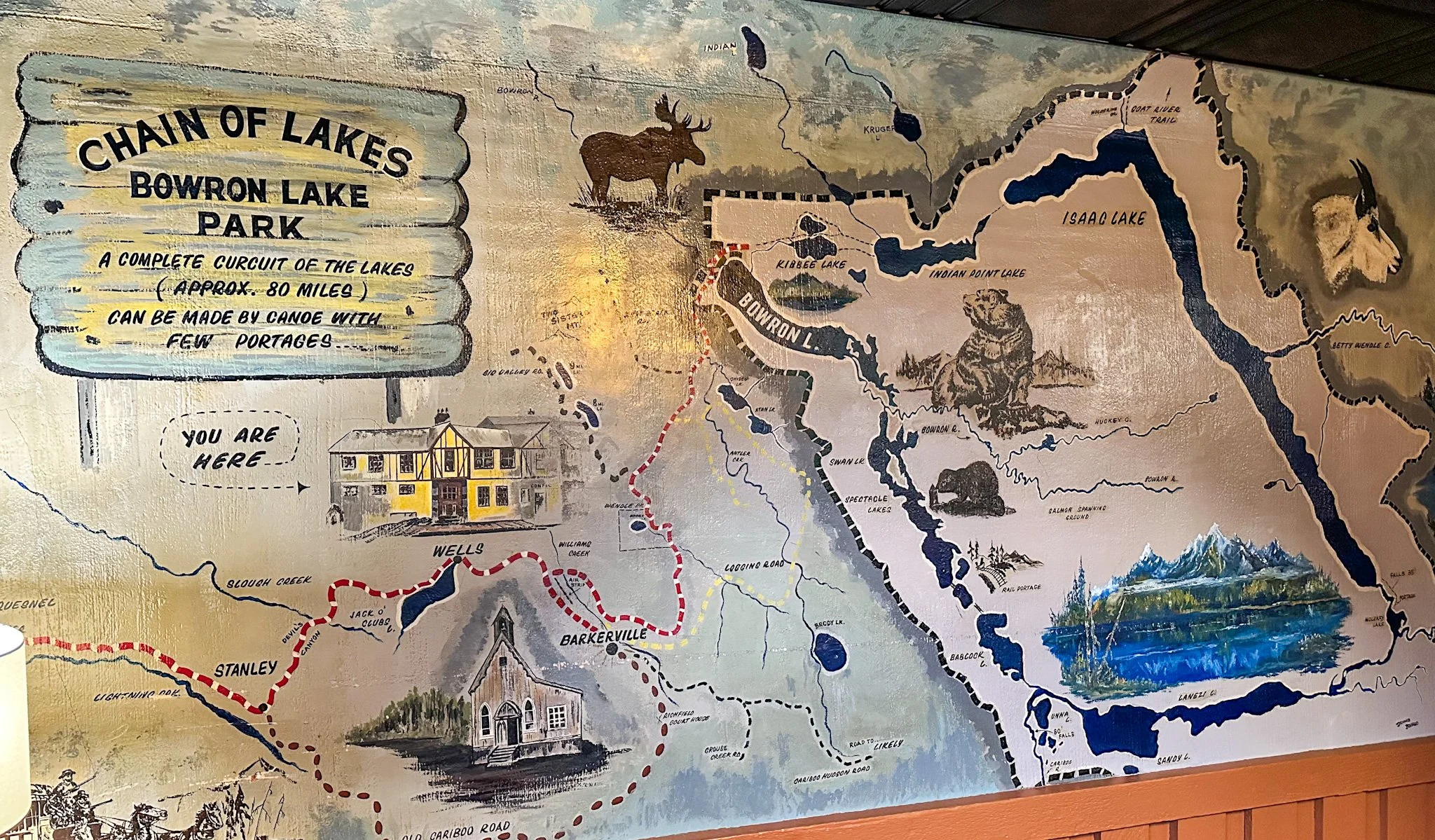 Map of Bowron Lakes Parkat the Wells Hotel featuring various lakes, trails, and landmarks, with text indicating it is a circuit of lakes approximately 80 miles long, designed for canoe trips.