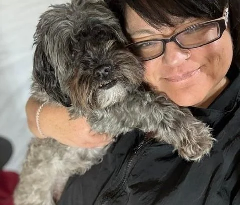 Owner of Nat’s Bark Boutique holding a freshly groomed small dog in Ranson West Virginia