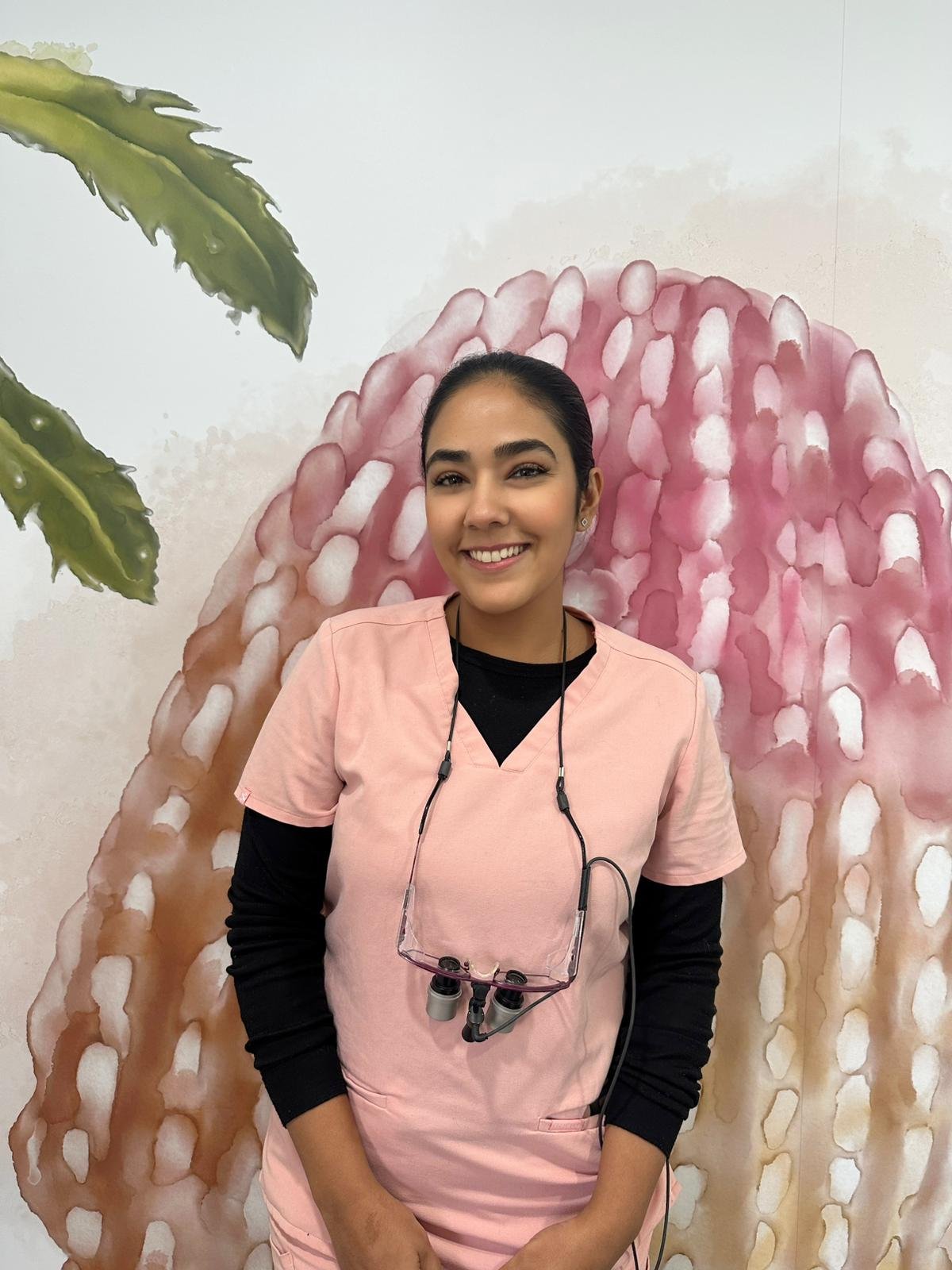 Dr Nisha Bedi Dentist in Adelaide in Orange Scrubs with a black underlayer