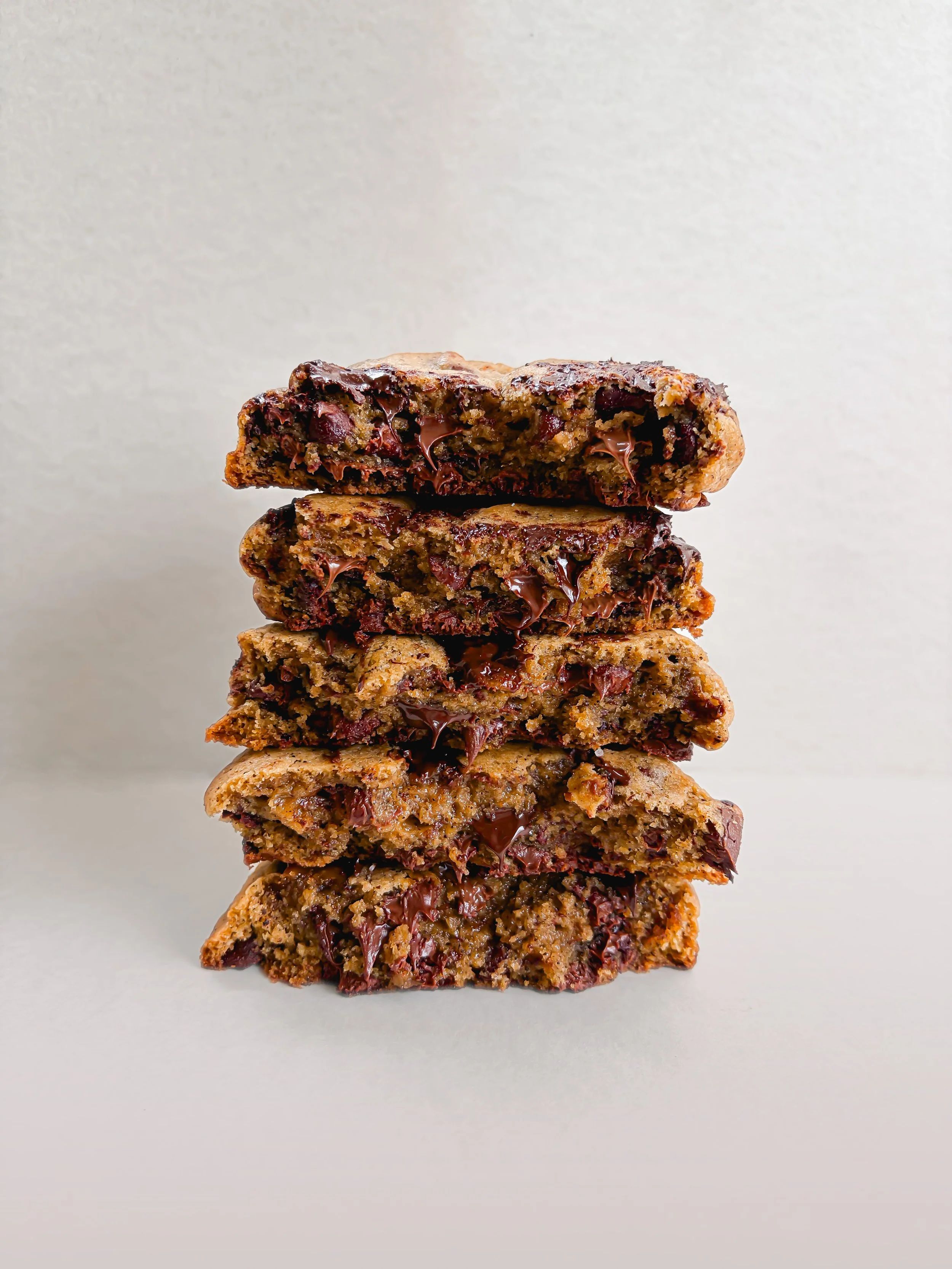 Stacked sliced chocolate chip cookie dough brownies with gooey chocolate chips visible inside.