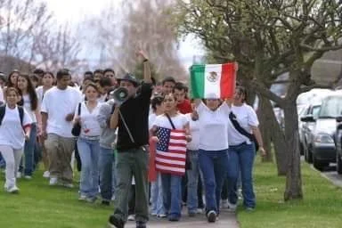 Pedro Gomez leading a Walla Walla High School student walkout with a bullhorn, walking alongside students