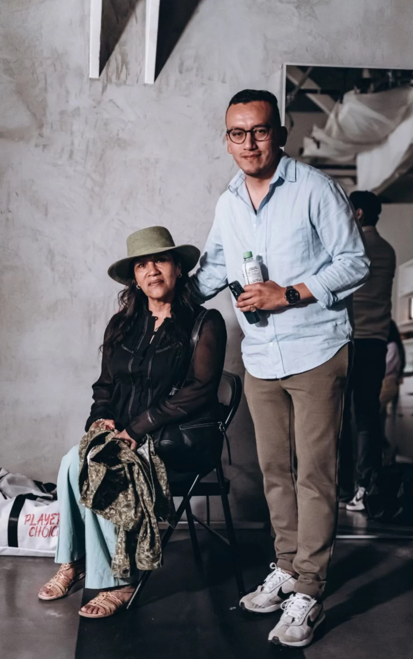 Pedro Gomez standing beside his mother during a filming of the Playerz Choice podcast