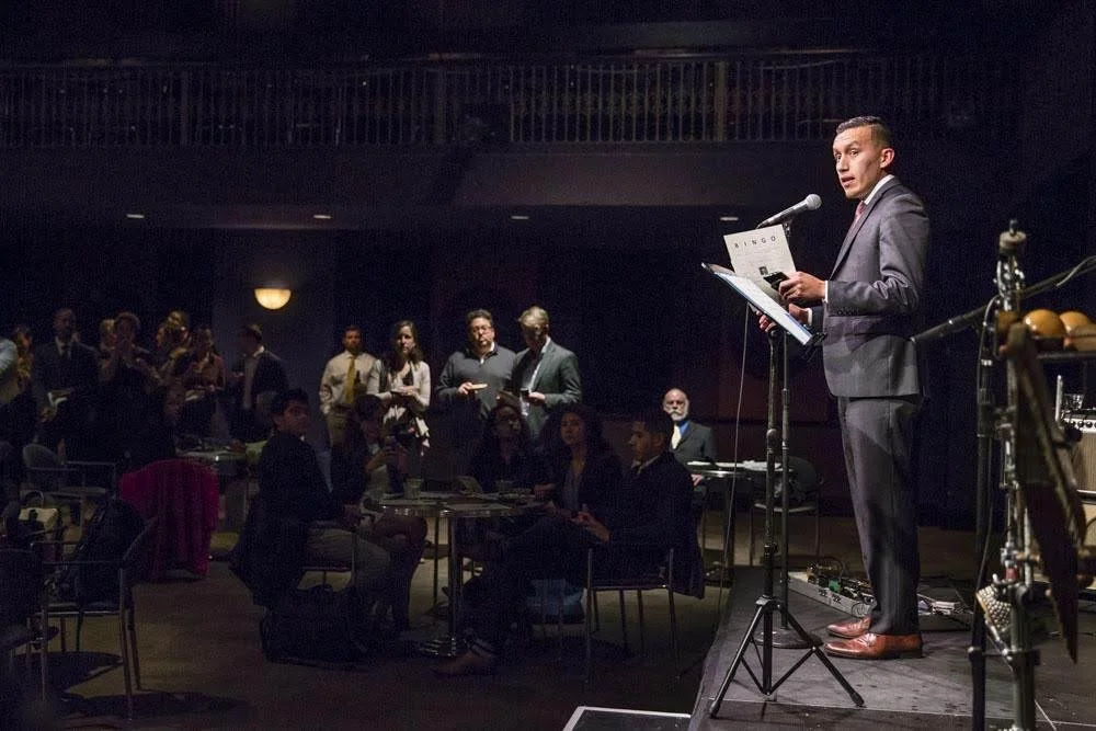 Pedro Gomez speaking to a crowd about civic engagement while wearing a suit