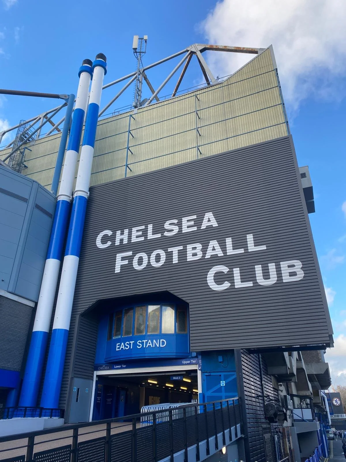 Exterior view of Chelsea Football Club stadium entrance labeled East Stand with large sign on building.
