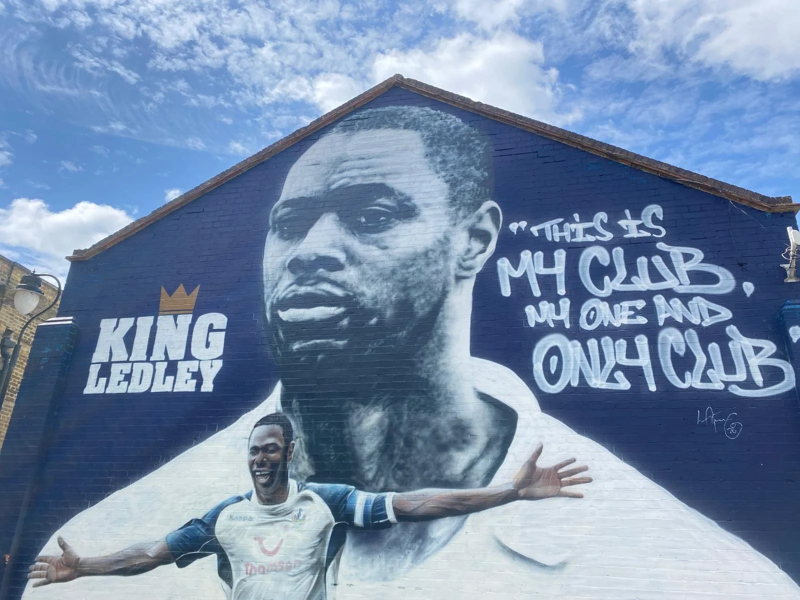 A mural of King Ledley, a football player, with a quote that says 'This is my club, my one and only club,' and an illustration of him in a football uniform celebrating.