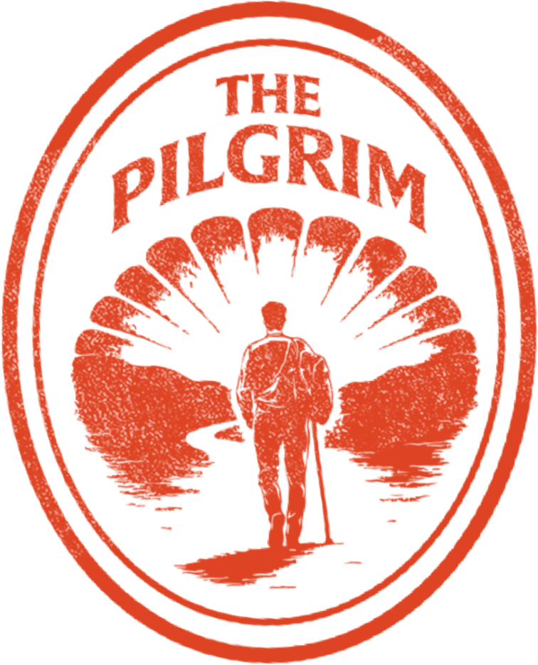 A logo with the text 'The Pilgrim' above a silhouette of a person standing on a path with trees and a body of water in the background, all in a red oval design.