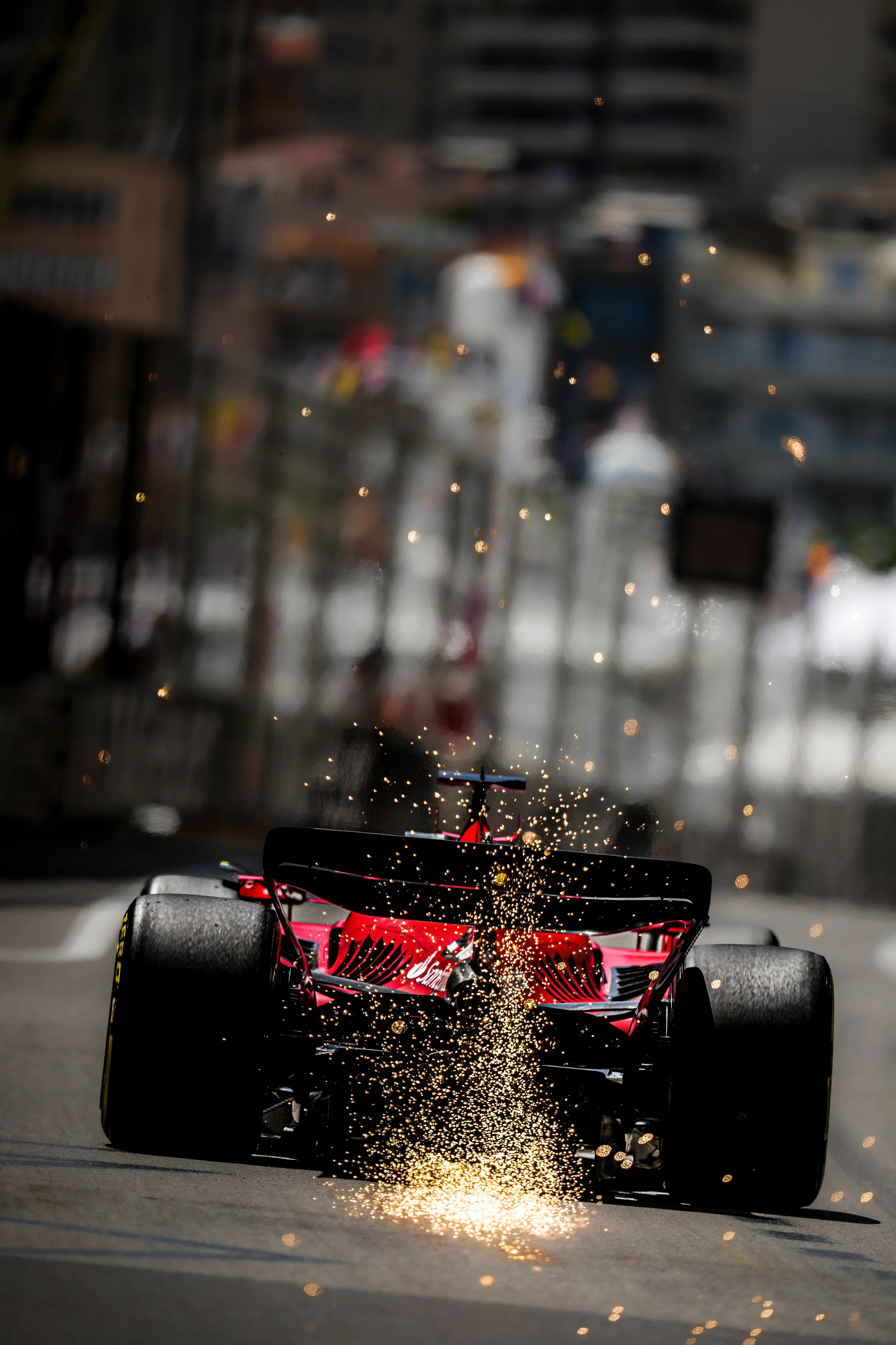 A race car driving on a track with sparks flying from underneath.