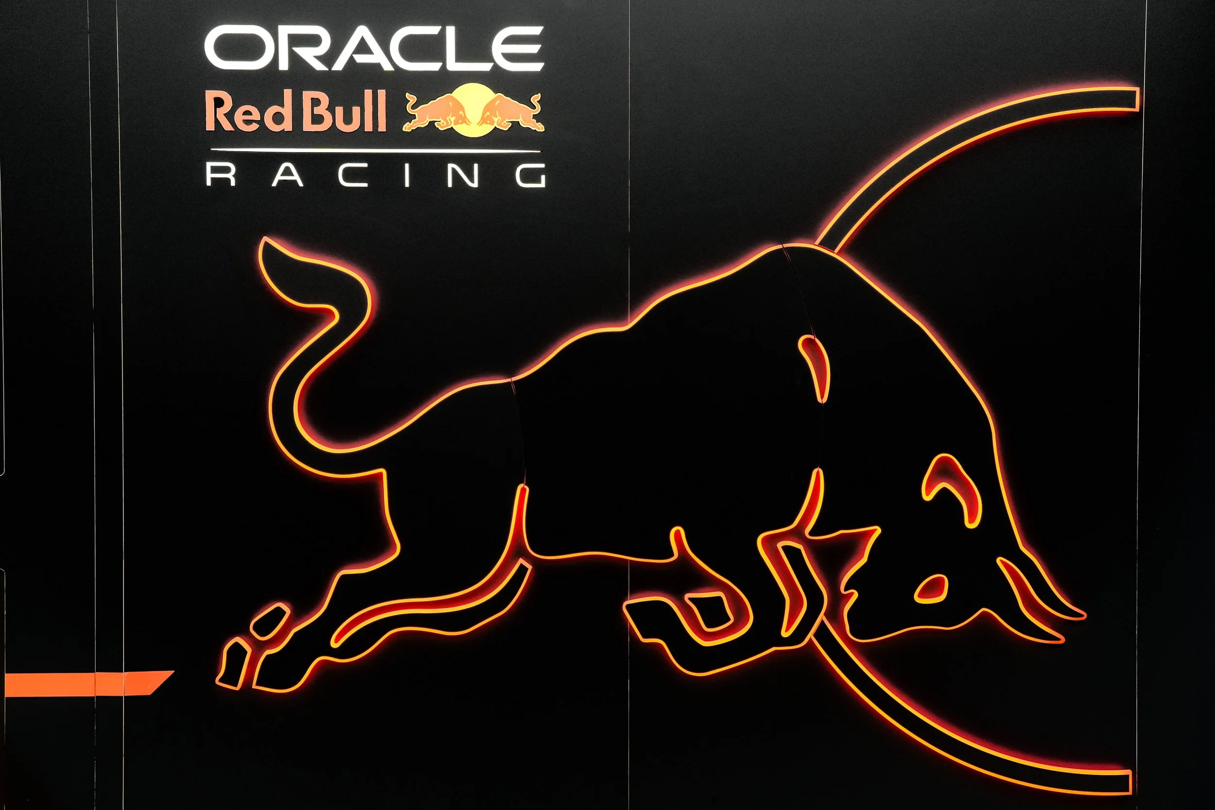 A neon sign of a running bull with the text 'Oracle Red Bull Racing' above it.