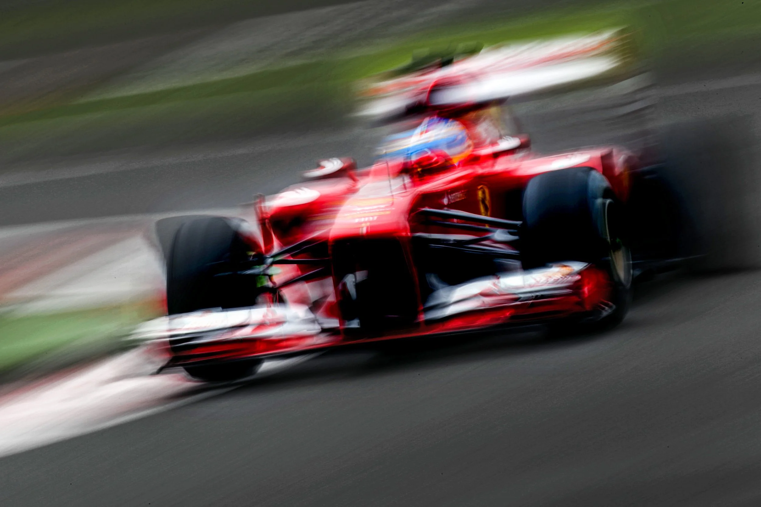 A red racing car speeding on a race track, releasing motion blur.