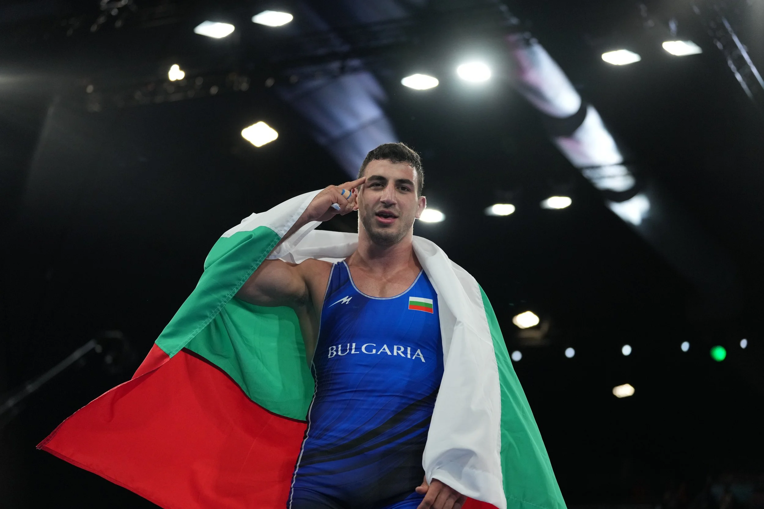 Simeon Novikov from Bulgaria is celebrating after a victory, draped in the Bulgarian flag, Paris 2024