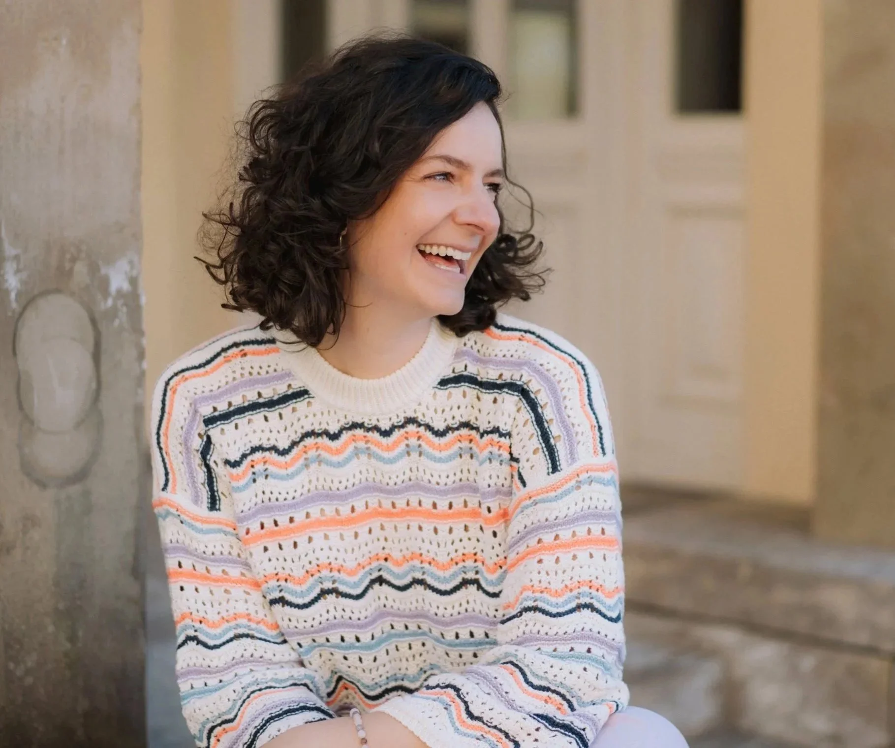 Kristina freie Doula, Birthkeeperin in Bayreuth und Umgebung lächelt aus vollem Herzen und blickt seitlich an Kamera vorbei.